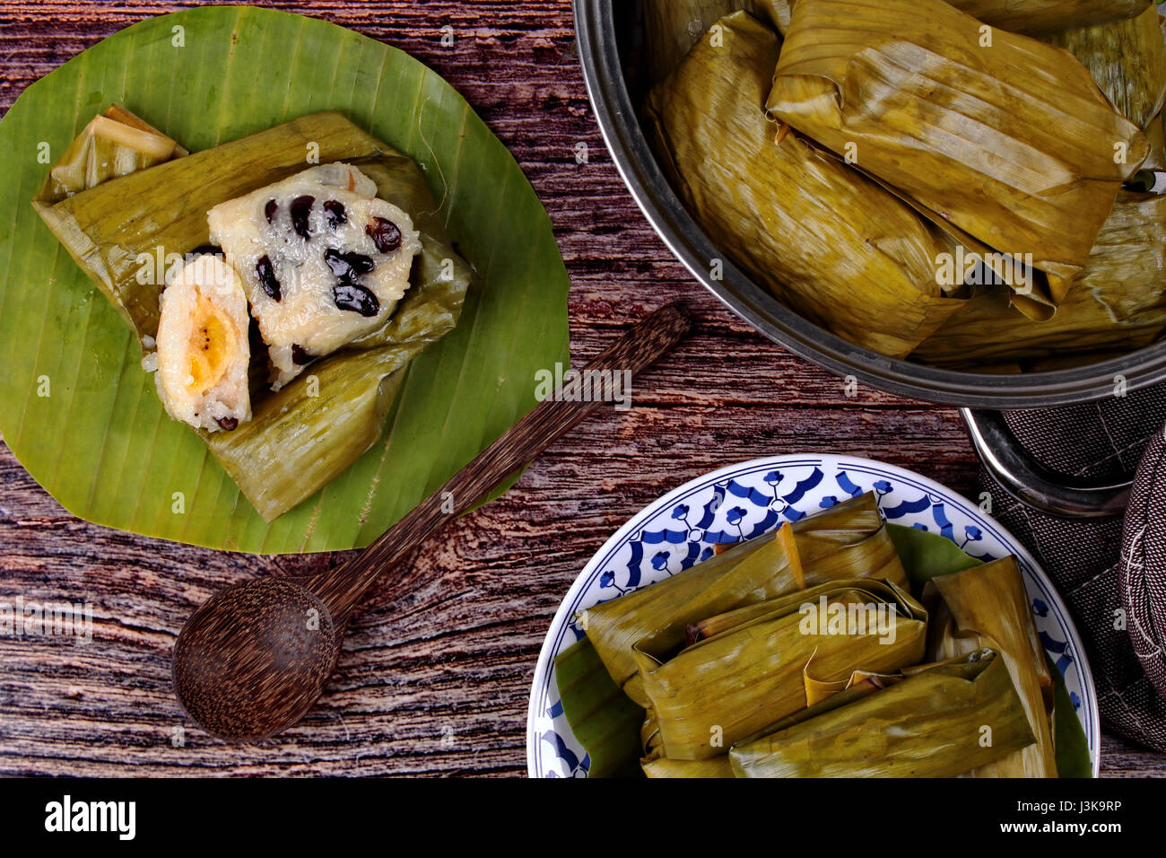 In casa Thai dessert, in streaming di riso e fagioli neri in banana leaf chiamata Khao Tom Mad in thailandese servita sul piatto con cottura in pentola. Foto Stock
