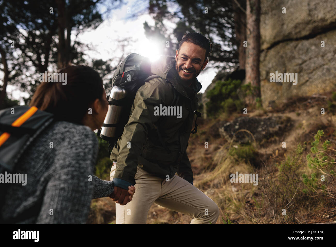 Escursionista aiutare la sua ragazza salita sul percorso del paese. Coppia giovane escursioni in montagna. Foto Stock