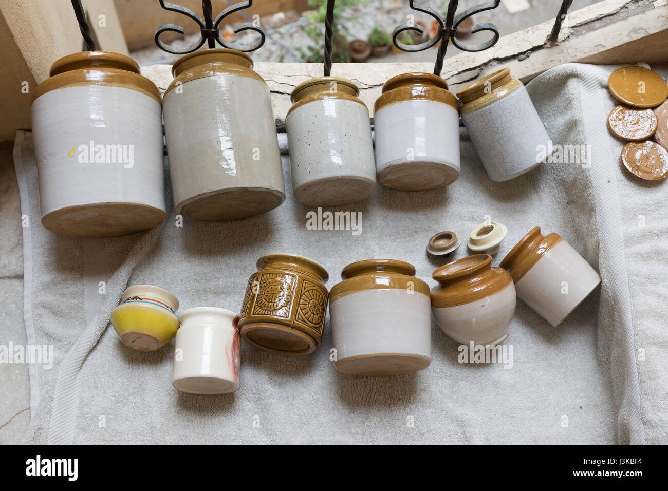 Indian ceramica invetriata vasetti per lo più utilizzato per la memorizzazione di sottaceti vengono tenuti fuori ad asciugare Foto Stock