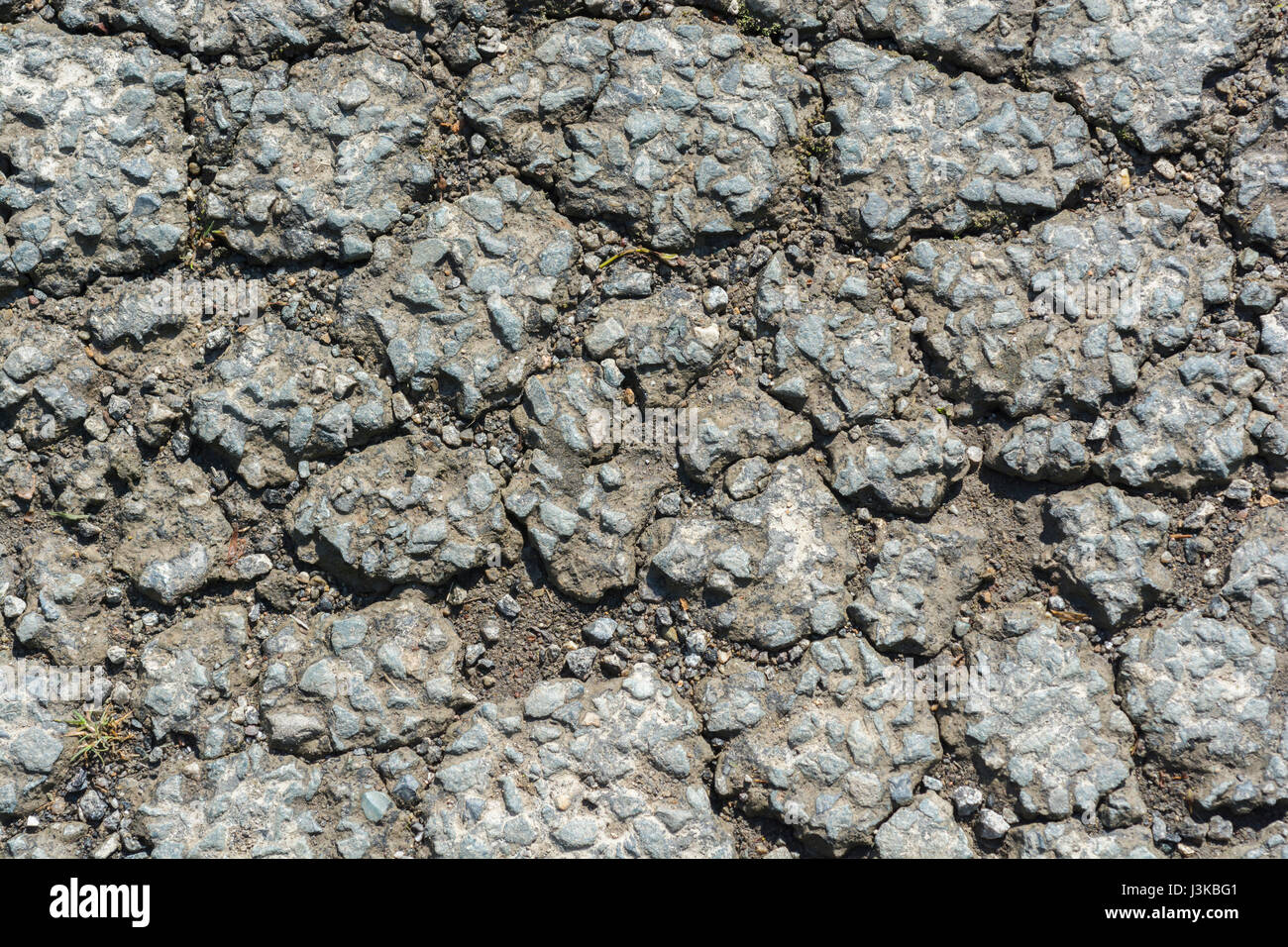 Rottura del manto stradale asfaltato con alligatore. Per cadute a pezzi, rotture, manutenzione scadente, metafora di rottura, consistenza ruvida, superficie irregolare. Foto Stock