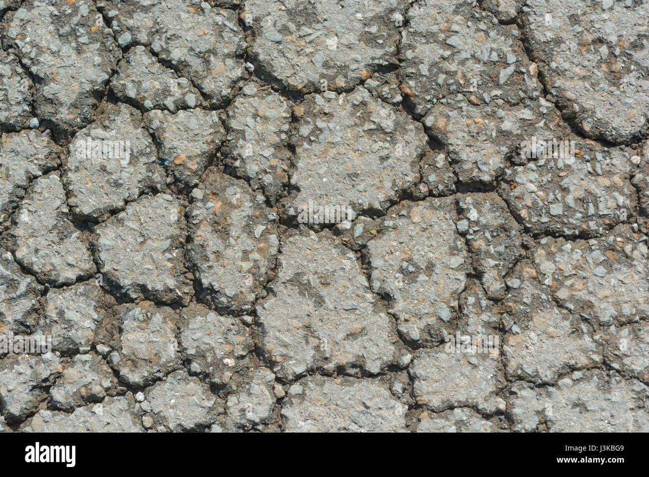 Rottura del manto stradale asfaltato con alligatore. Per cadute a pezzi, rotture, manutenzione scadente, metafora di rottura, consistenza ruvida, superficie irregolare. Foto Stock