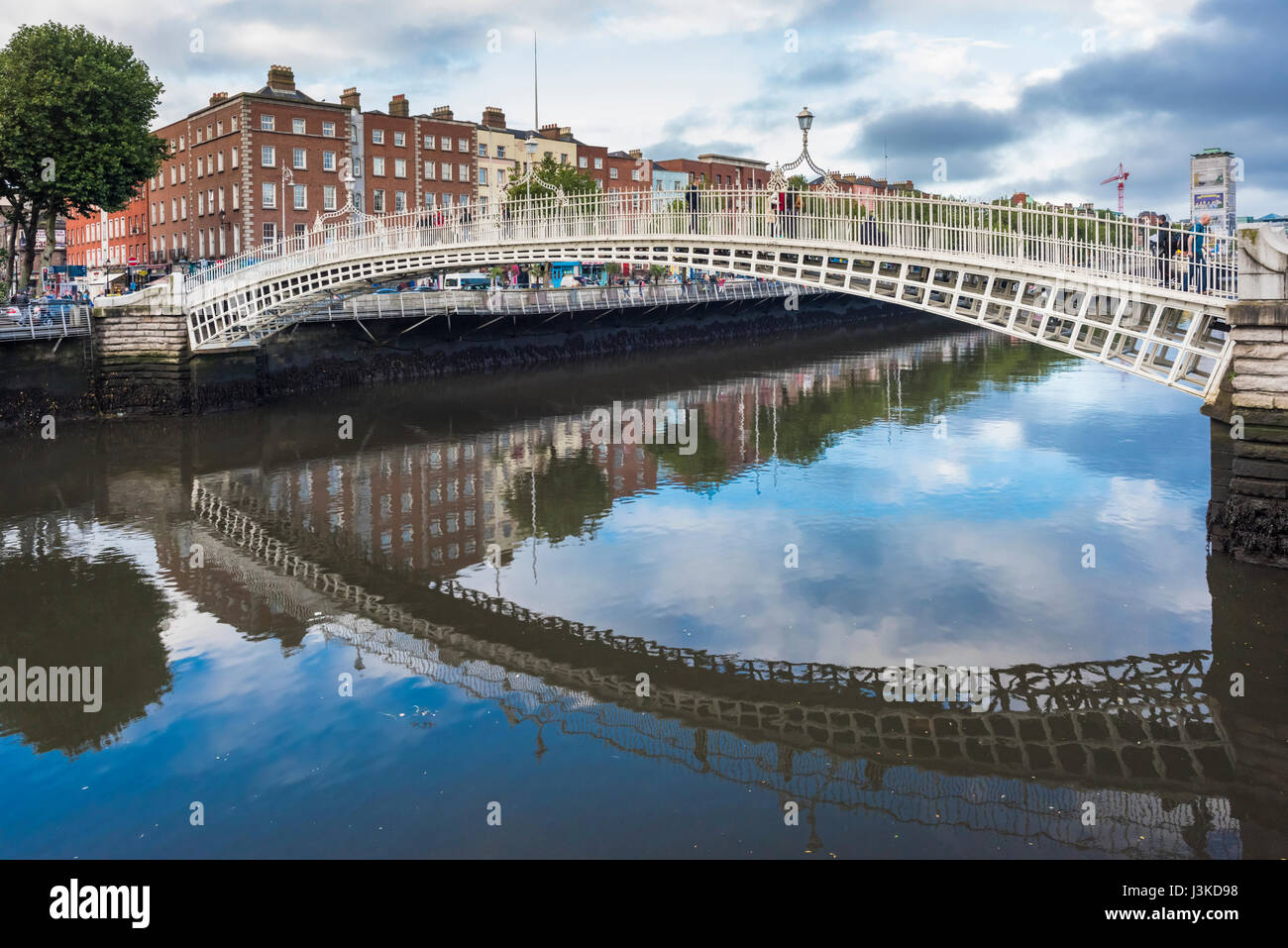 L'Ha'penny Bridge, ufficialmente conosciuta come il Liffey Bridge, su un tranquillo fiume Liffey, centro di Dublino, Irlanda Foto Stock