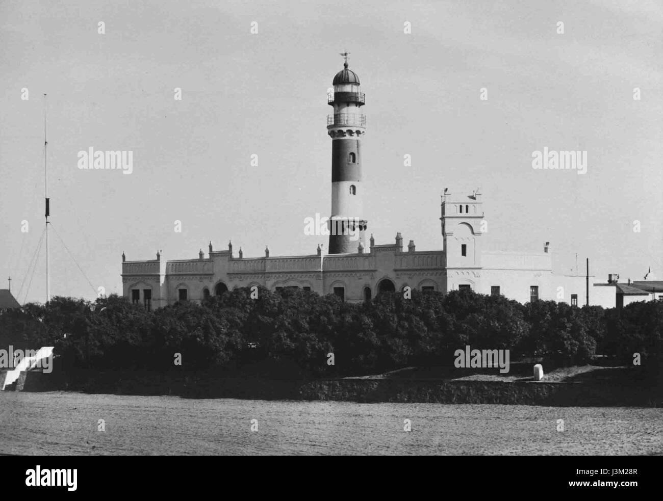 L'area del porto e il faro di Swakopmund, una città costiera della Namibia. L'immagine mostra il ruolo critico del porto nel trasporto locale e l'iconico faro che funge da guida per le navi. Foto Stock