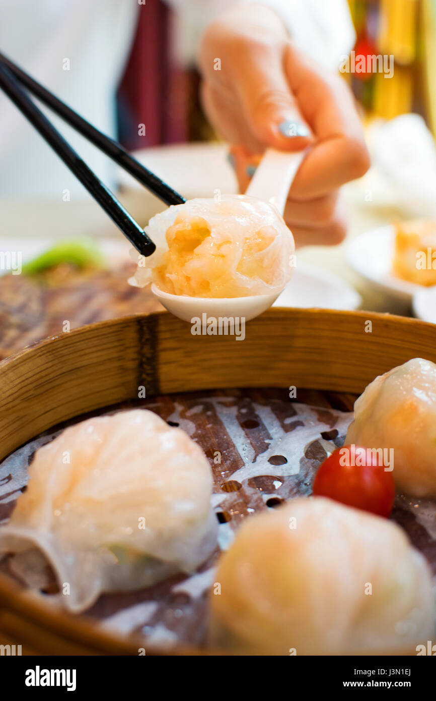 Ragazza tenendo i gamberi gnocco con bacchette in un ristorante Foto Stock