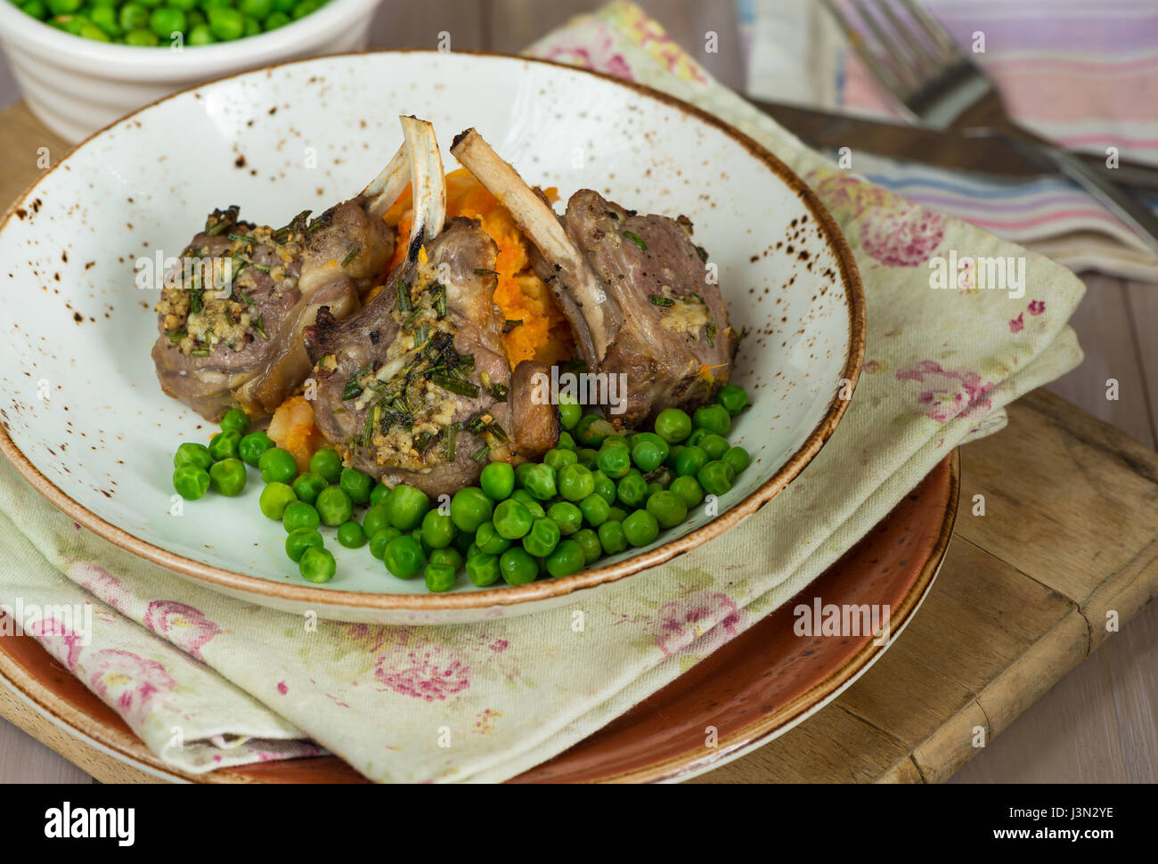 Il rosmarino costolette di agnello a cena con la carota e pastinaca mescolanza e piselli verdi Foto Stock