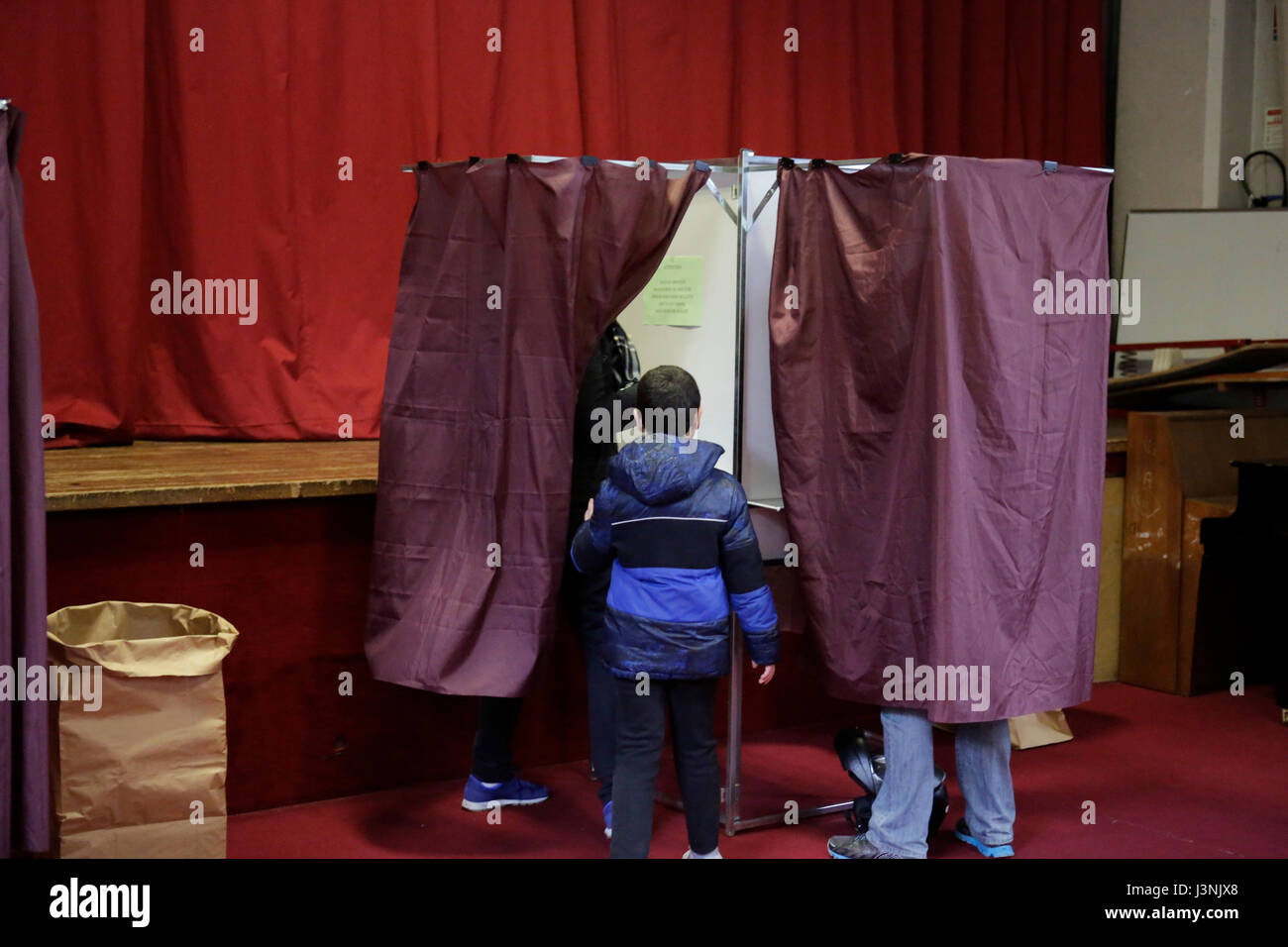 Parigi, Francia. Il 7 maggio 2017. Un padre e i suoi brani in una cabina di voto, colata dal padre la votazione. Circa 47 milioni di francesi sono chiamati alle urne per eleggere il prossimo Presidente della Francia. Il candidato indipendente Emmanuel Macron è atteso a prendere la vittoria sul suo rivale Marine Le Pen dall'ala destra Fronte nazionale. Foto Stock