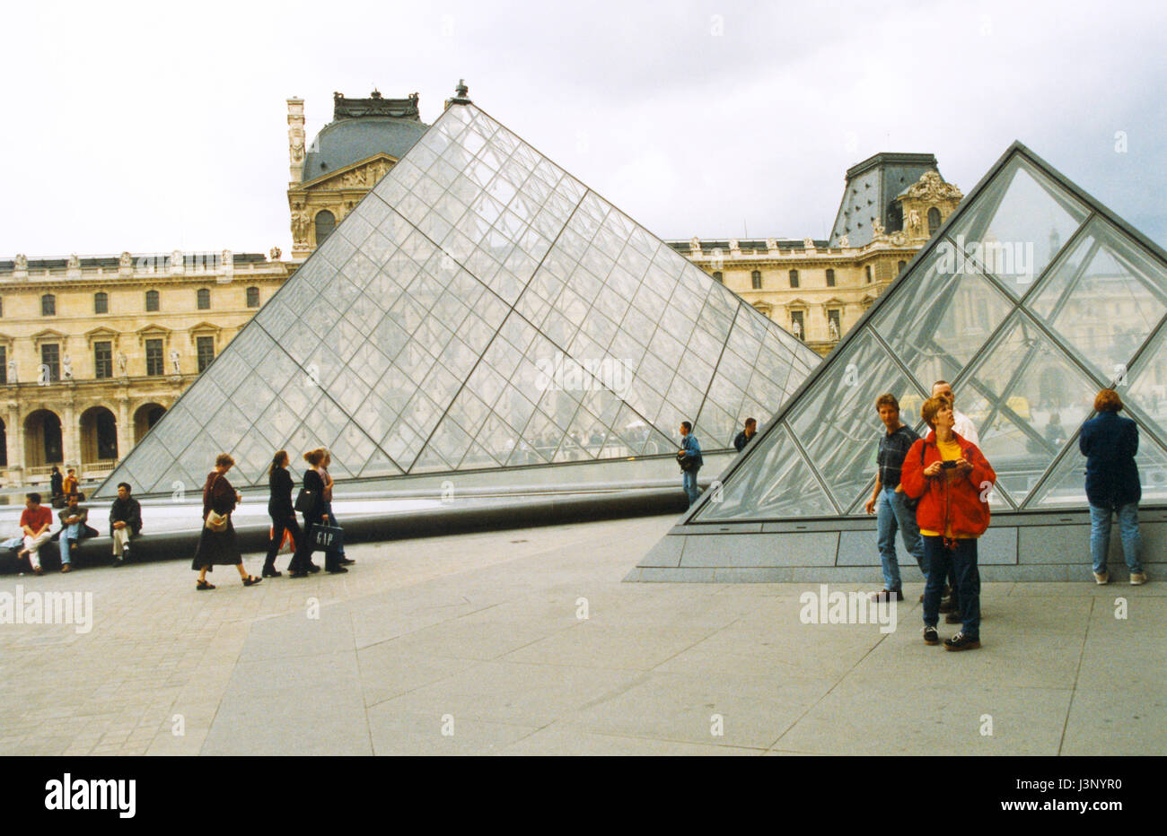 LOUVRE Francia con le piramidi di vetro di fronte al vecchio edificio storico 2000 Foto Stock