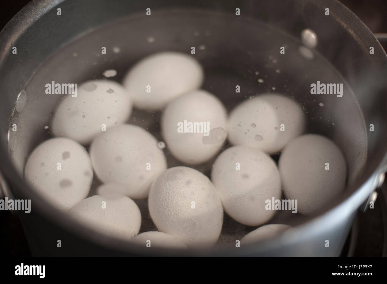 Le uova bianche ebollizione in una pentola Foto Stock