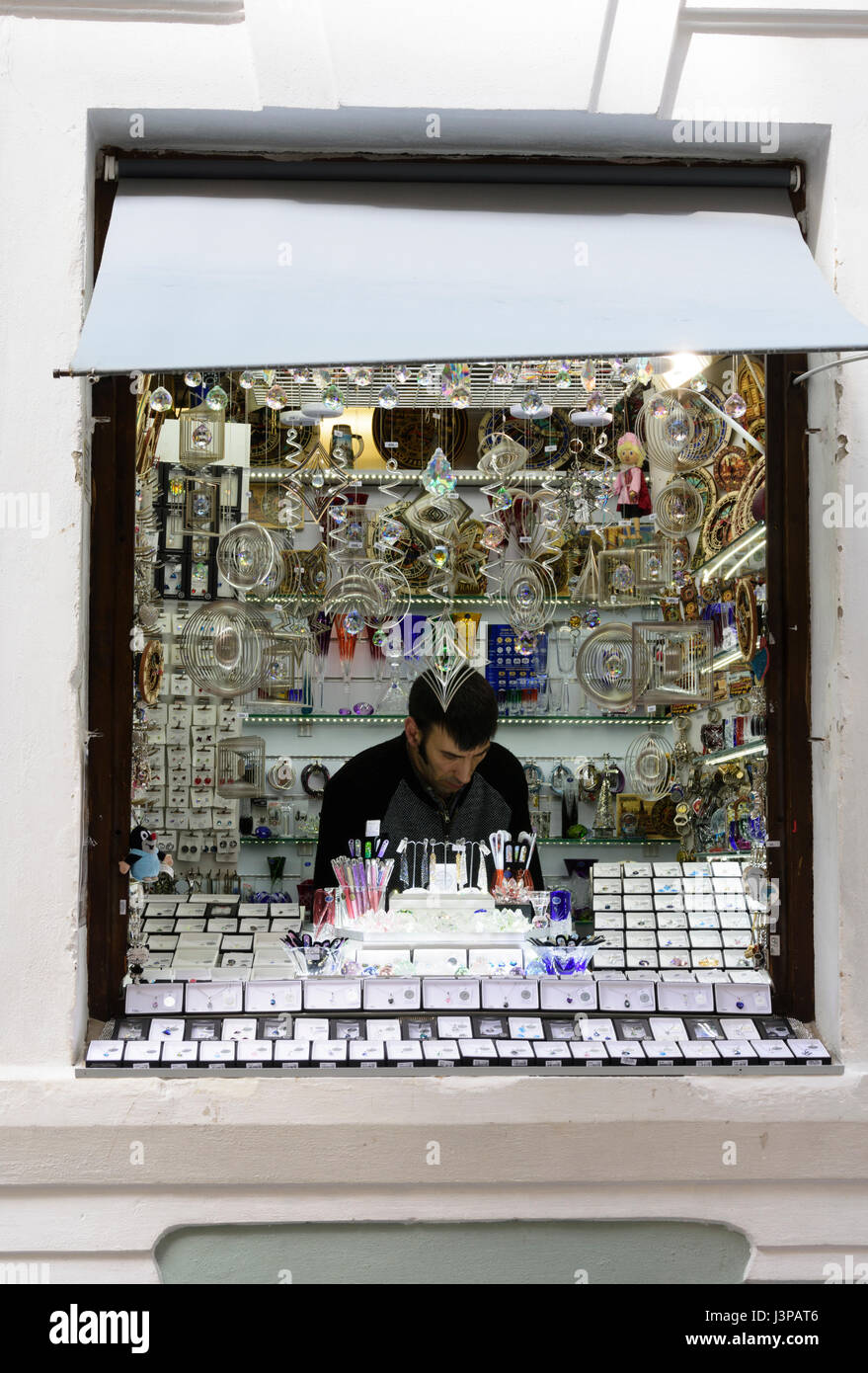 Negoziante fra il suo display del cristallo di Boemia negozio di souvenir. Praga, Repubblica Ceca. Foto Stock
