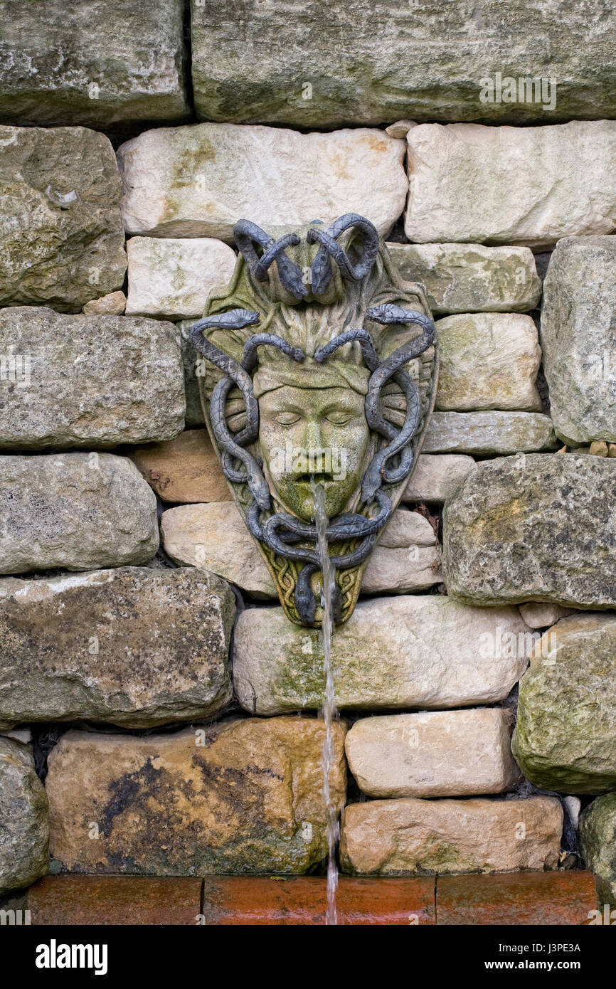 Funzione di acqua su un muro di pietra. Foto Stock