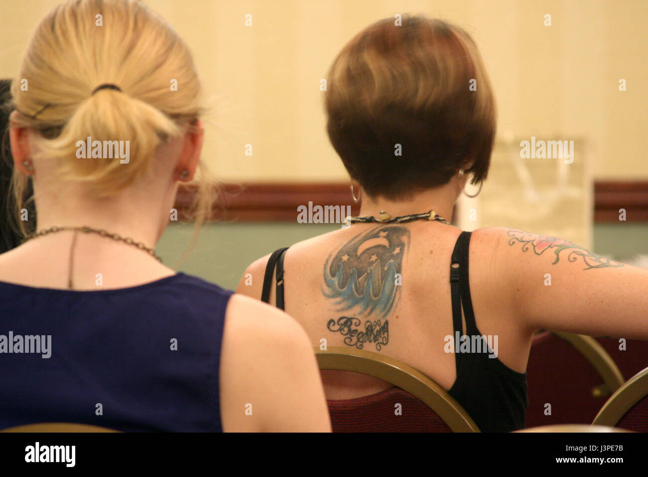 Donna con tatuaggi sul braccio e sul retro Foto Stock