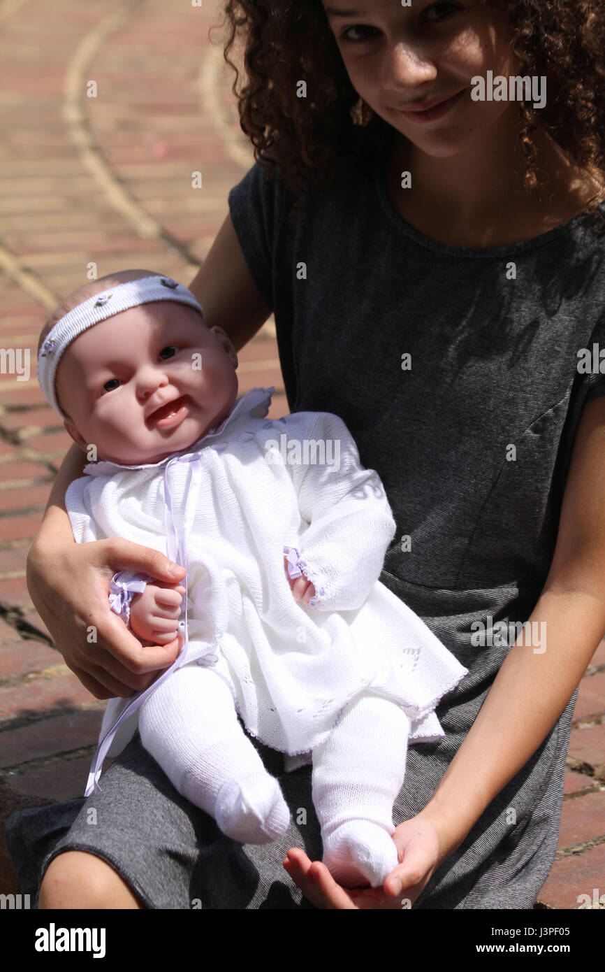 Ragazza giovane con baby doll in grembo Foto Stock