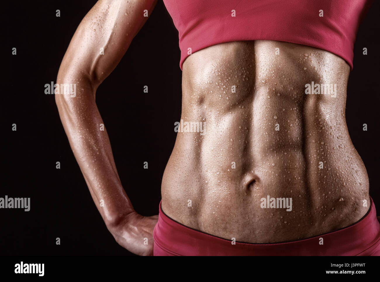 Close-up di muscoli addominali giovane atleta su sfondo nero Foto Stock