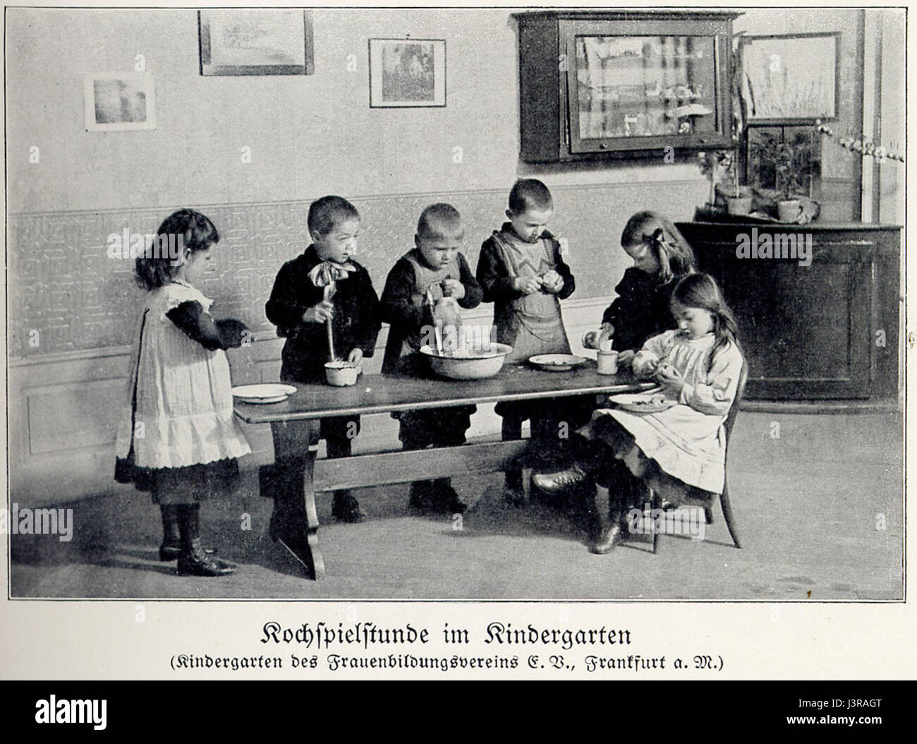 Questo titolo si riferisce a una rappresentazione di un'ora di gioco dell'asilo intorno all'anno 1900, che mostra le pratiche educative della prima infanzia e l'ambiente educativo di quel periodo. Riflette l'approccio allo sviluppo dell'infanzia e all'apprendimento basato sul gioco tra la fine del XIX e l'inizio del XX secolo. Foto Stock