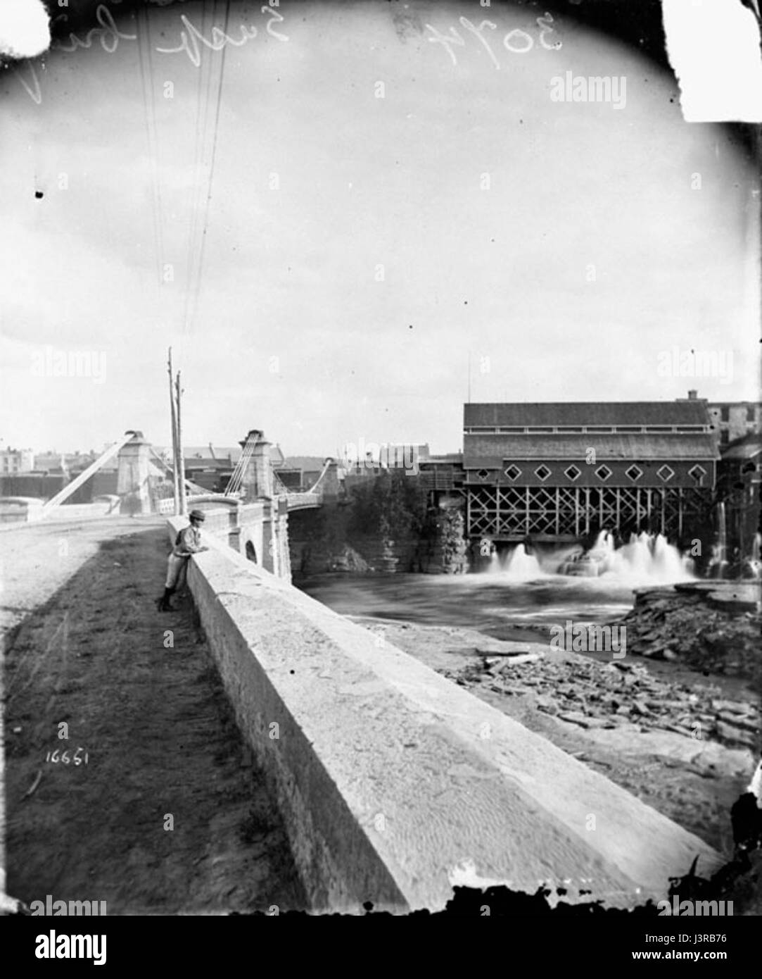 Il ponte sospeso J. R. Booth Mills, costruito nel 1870, è una struttura storica situata a Ottawa, Canada. Fu uno dei primi esempi di un ponte sospeso nella regione, fornendo connettività essenziale per i trasporti e il commercio durante la fine del XIX secolo. Il ponte rimane un pezzo importante della storia ingegneristica di Ottawaâ. Foto Stock