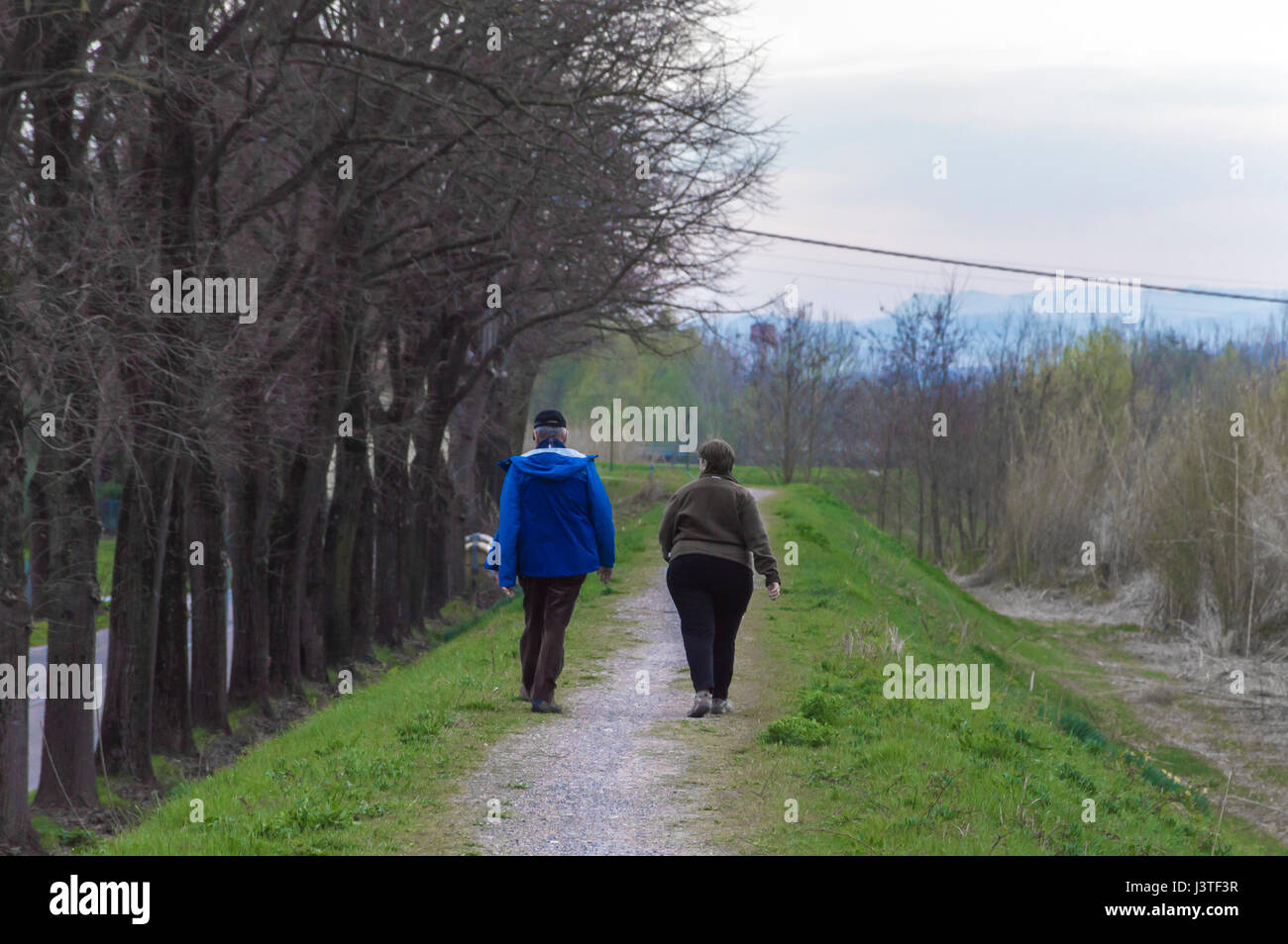Vecchia coppia camminare durante la primavera tempo in ore di pomeriggio Foto Stock