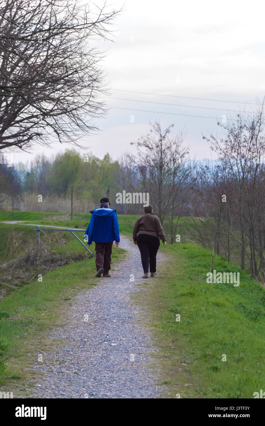 Vecchia coppia camminare durante la primavera tempo in ore di pomeriggio Foto Stock