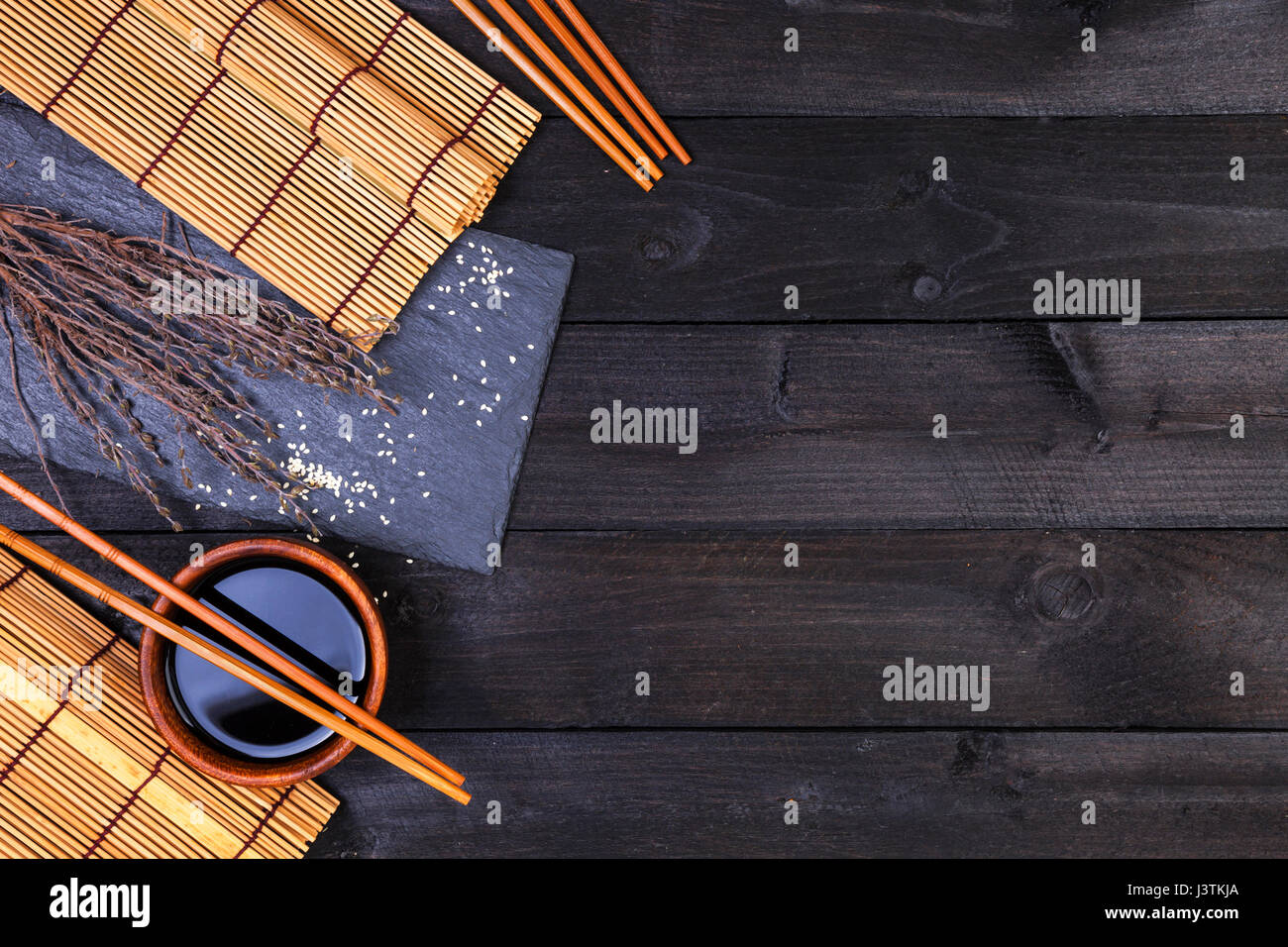 Bacchette di Sushi e salsa di soia su sfondo nero. Vista da sopra con copia spazio. Foto Stock