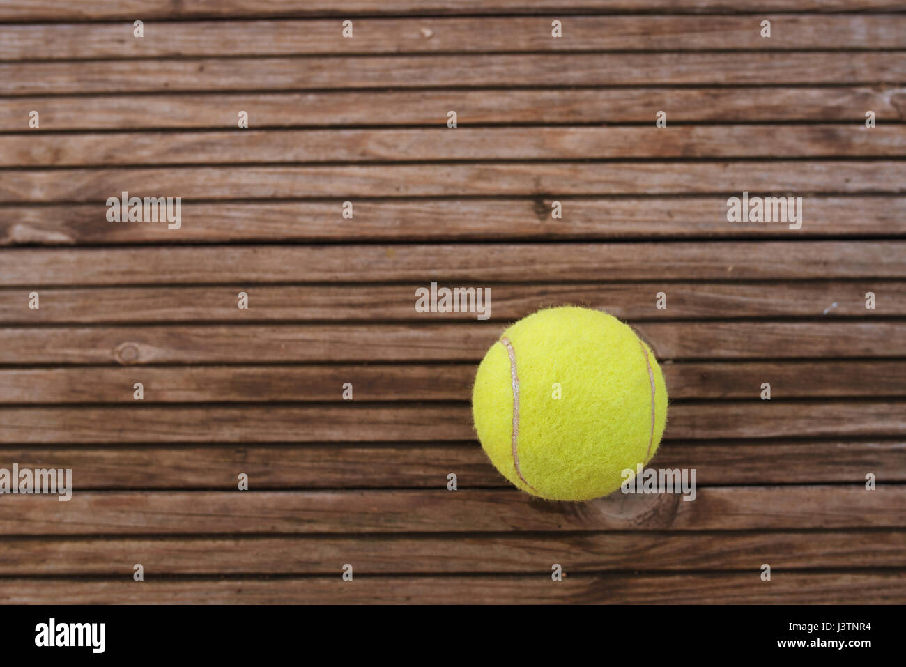 Palla da tennis su sfondo di legno Foto Stock