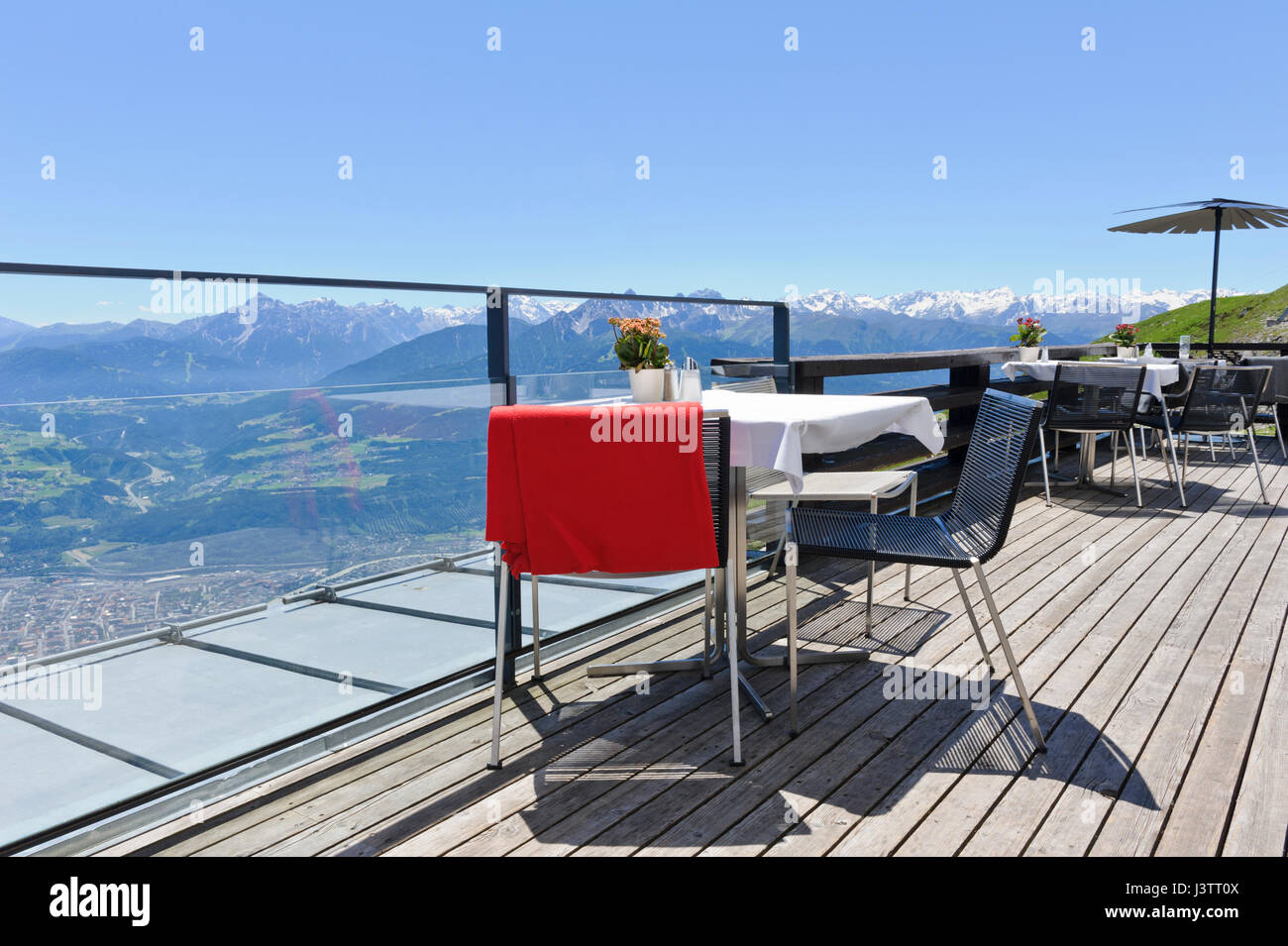 Tavoli e sedie con una vista panoramica delle montagne in Seegrube Stazione della Funivia ristorante, Innsbruck, in Tirolo, Austria Foto Stock