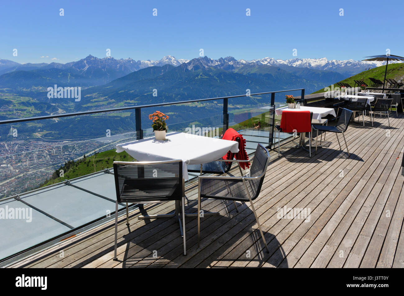 Tavoli e sedie con una vista panoramica delle montagne in Seegrube Stazione della Funivia ristorante, Innsbruck, in Tirolo, Austria Foto Stock