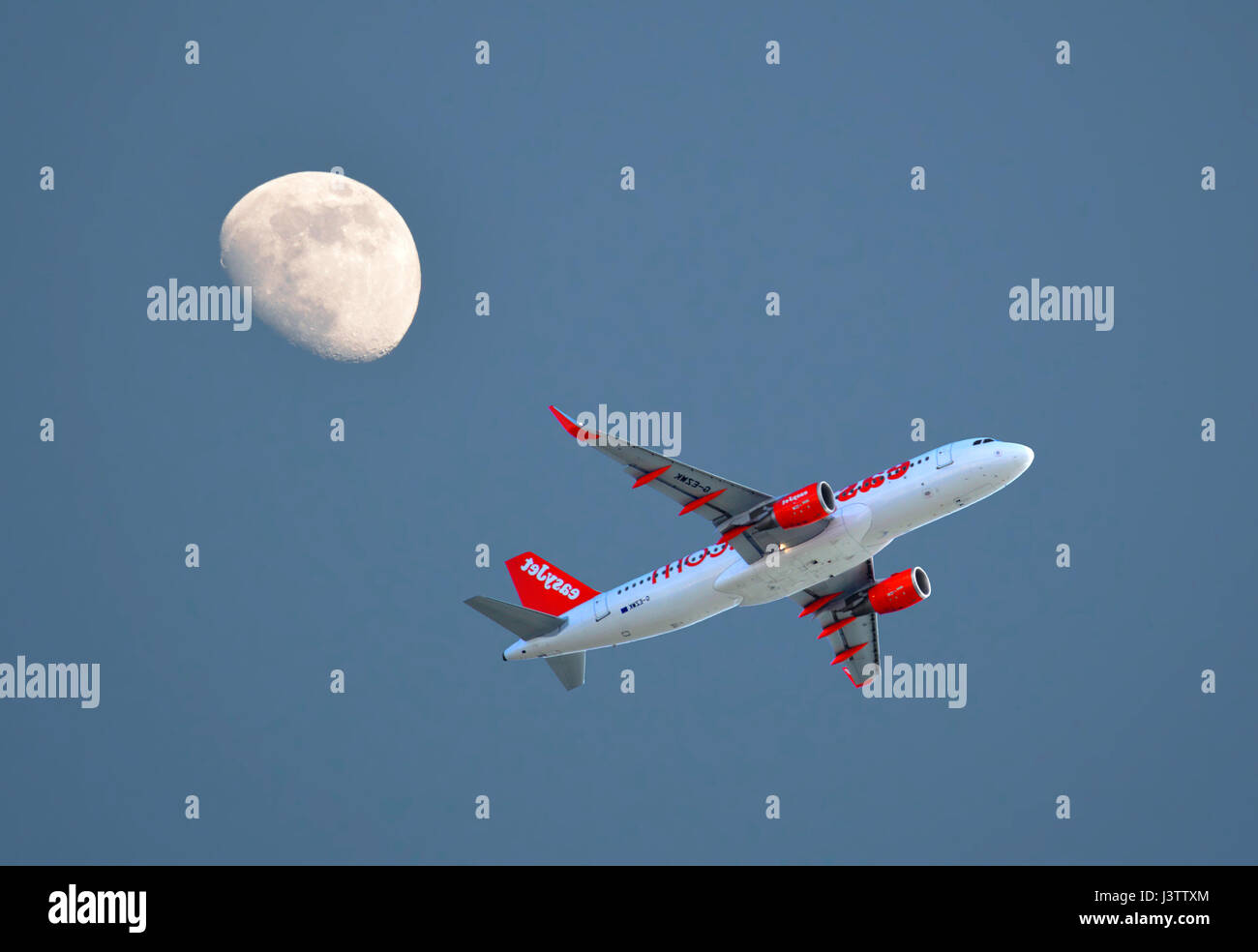 Easyjet Airbus A320 di aeromobili in fase di decollo dall'Aeroporto di Faro con un tre quarto di luna nel cielo di sera Foto Stock