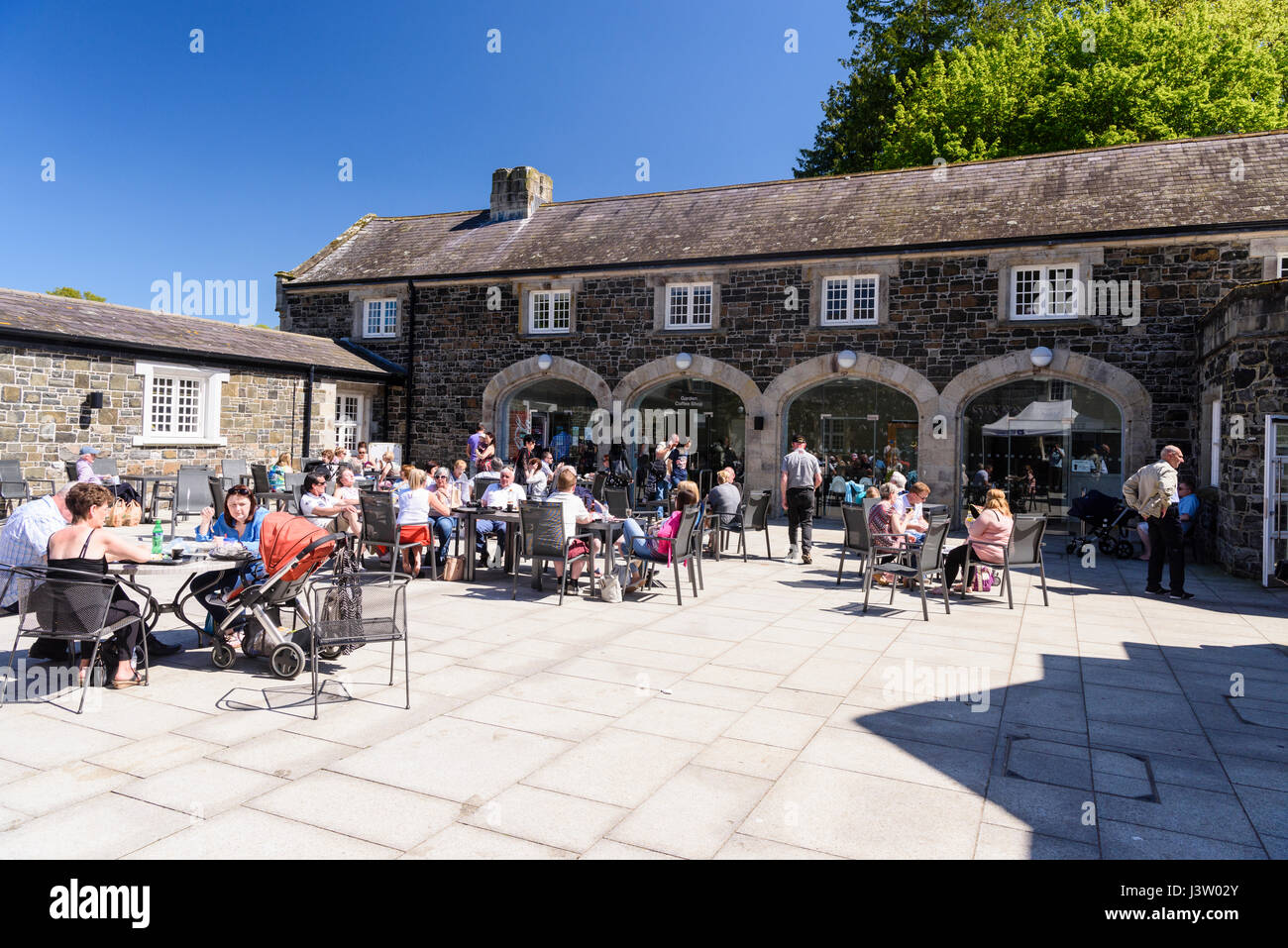 Un sacco di persone al di fuori della caffetteria di Clotworthy House, Antrim Castle Gardens, Irlanda del Nord, durante una giornata di sole. Foto Stock
