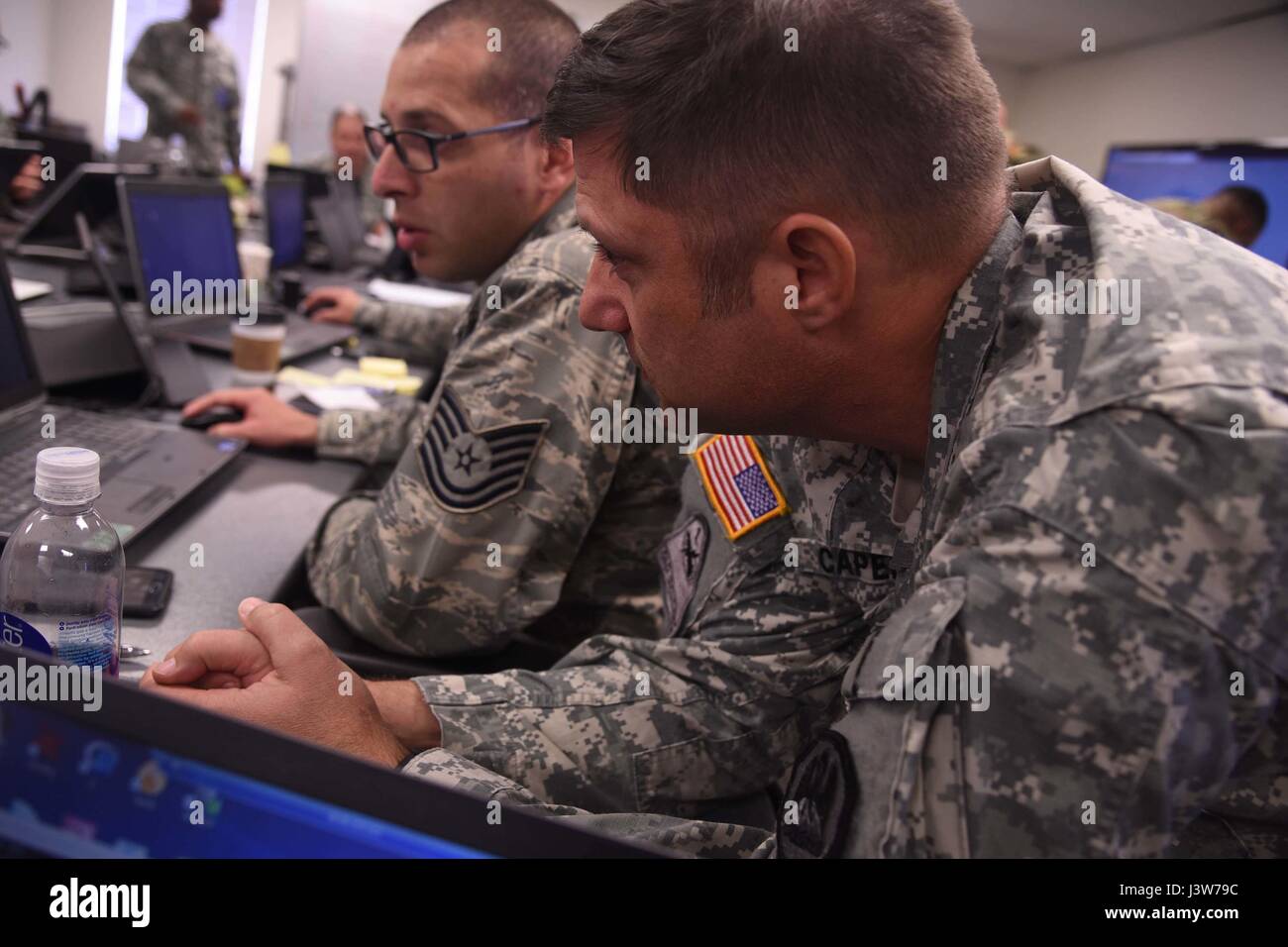 Louisiana National Guard Lt. Col. Henry Capello, esercitare il comandante della Cyber scudo 17, guarda come Louisiana Air National Guardsman e Cyber Defense Incident Response Team stati Tech Sgt. Joseph Mitchell 159Fighter Wing pratica la sua Cyber Defense abilità durante l'esercizio a Camp W.G. Williams in Bluffdale, Utah, Aprile 1, 2017. Circa 20 Louisiana soldati e aviatori sono la formazione con 850 altre guardie da oltre 42 Stati e territori, nonché l'FBI, Department of Homeland Security e più di 30 enti non pubblici tra cui Entergy, Lockheed Martin, Mons Foto Stock