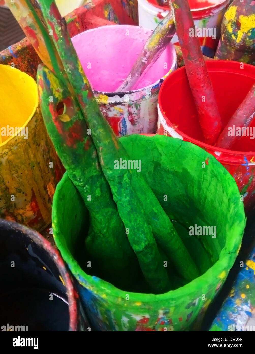 Primo piano di alcuni utilizzati spazzola di vernice di colore differente pots Foto Stock