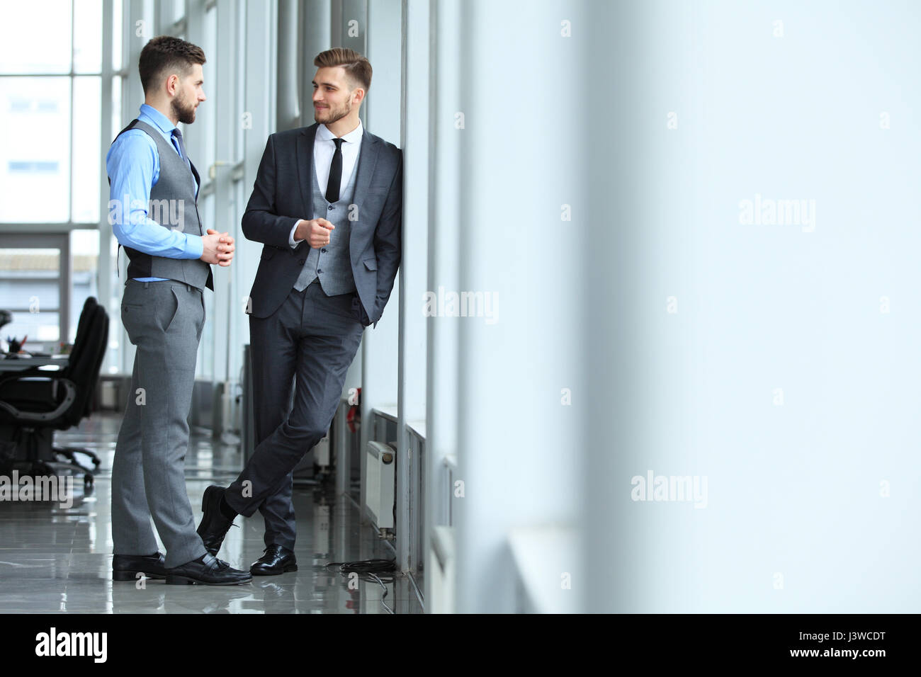 Due colleghi di lavoro alla riunione in ufficio moderno interno. Foto Stock