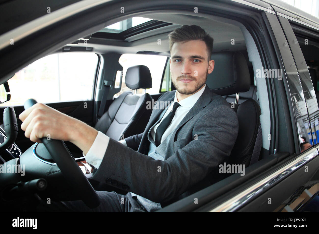 Ritratto di un bel ragazzo alla guida della sua auto. Foto Stock