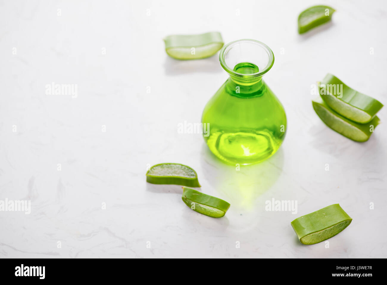 Aloe vera olio essenziale e Aloe foglie su uno sfondo bianco. Foto Stock