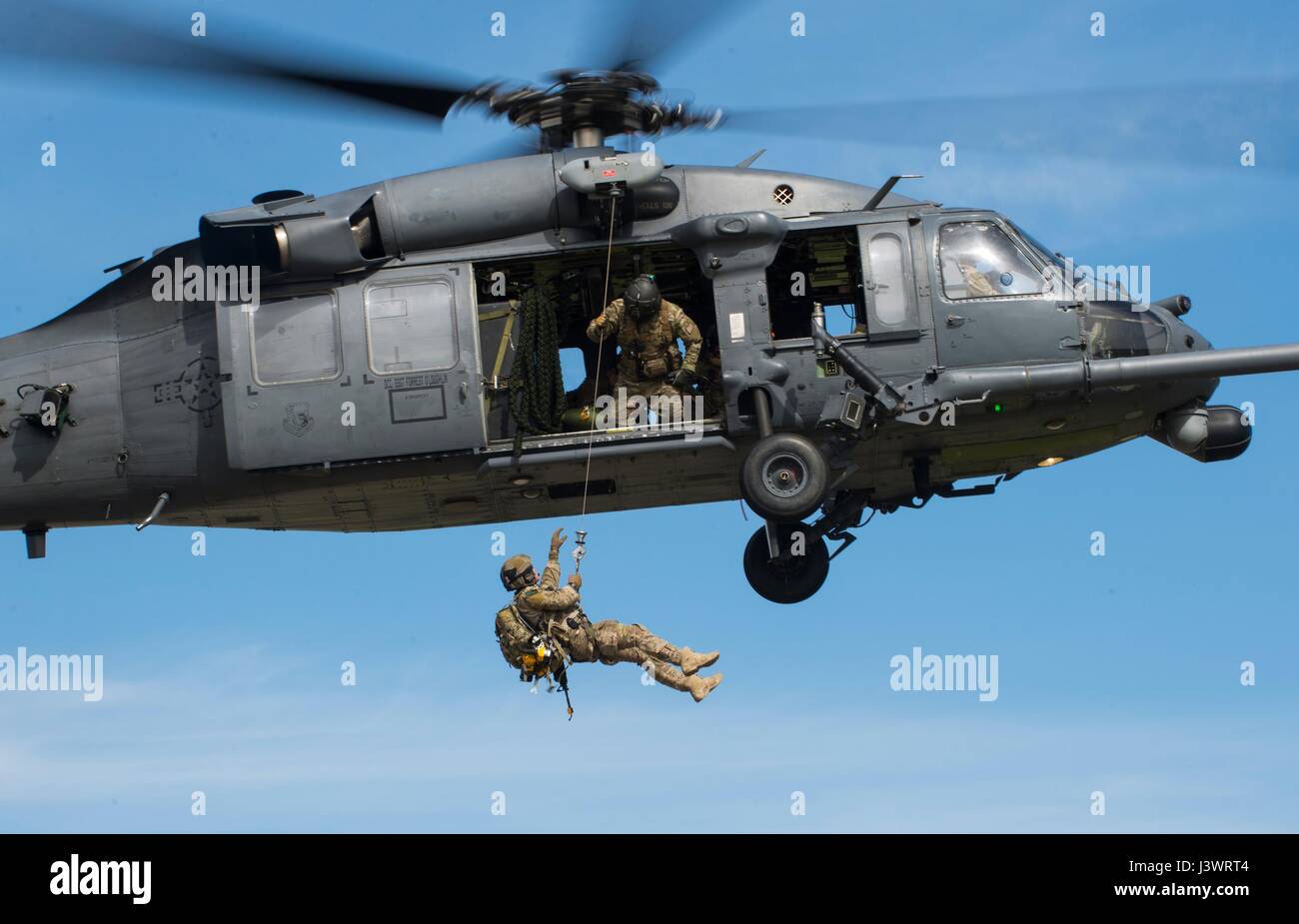 Un U.S. pararescueman soldato è issato su un USAF HH-60G Pave Hawk elicottero durante un combattimento di ricerca e salvataggio di dimostrazione presso la Royal Air Force Lakenheath Aprile 21, 2016 in Lakenheath, Inghilterra. (Foto di Emerson Nunez /US Air Force via Planetpix) Foto Stock