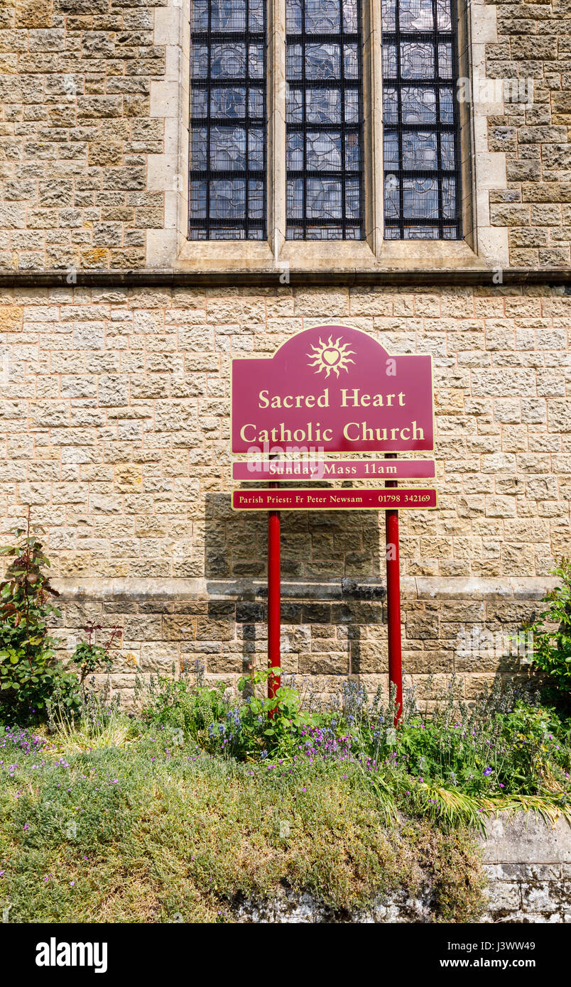 Firmare con il nome e la messa domenicale del tempo, Sacro Cuore chiesa cattolica, Petworth, una città del West Sussex, sud-est Inghilterra Foto Stock