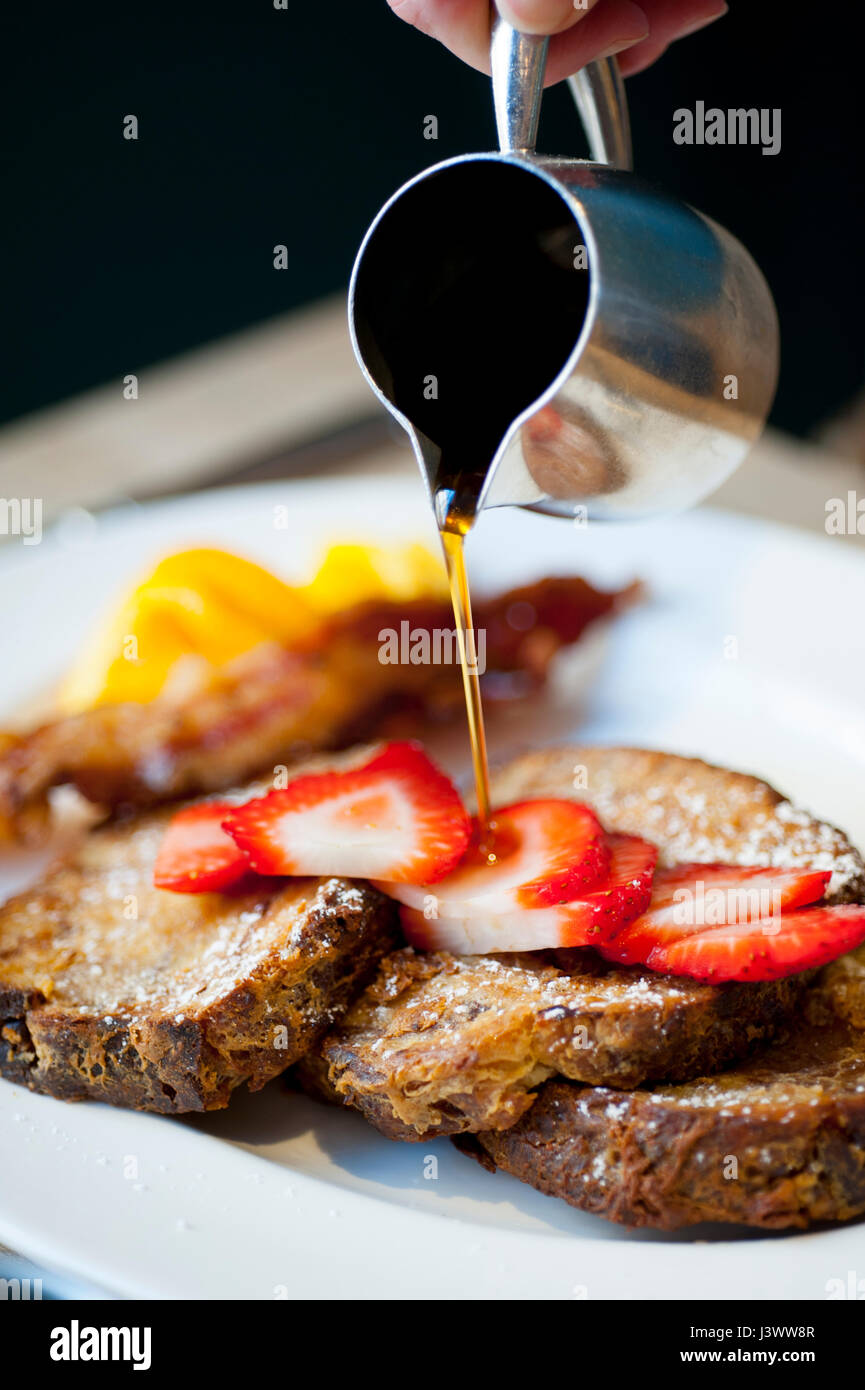 Cibo, i pasti prima colazione toast alla francese con strawberrie e sciroppo di essere riversato su di esso Foto Stock