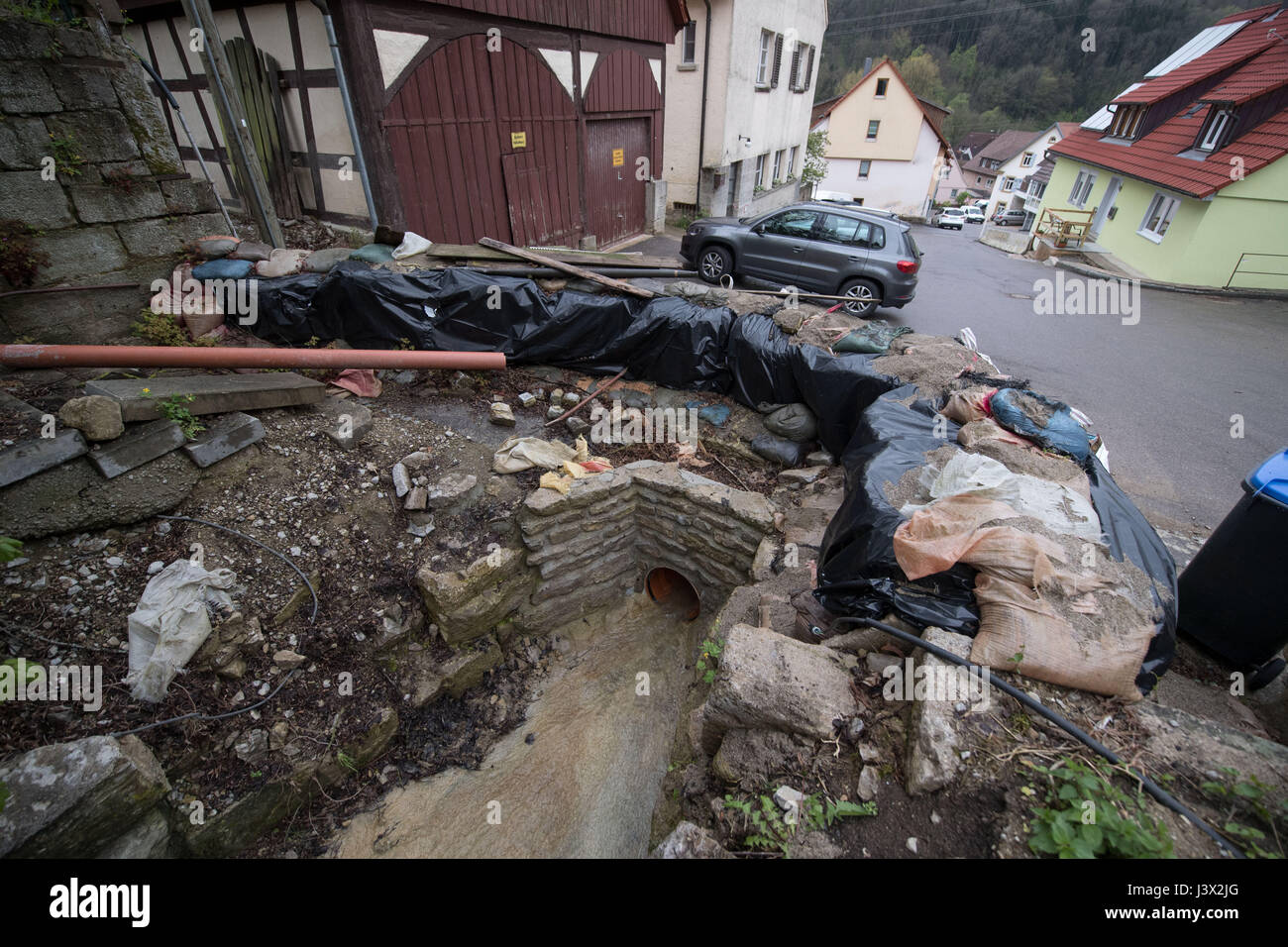 Braunsbach, Germania. 03 Maggio, 2017. Sandsacks giacciono al di sopra del flusso Schlossbach a Braunsbach, Germania, 03 maggio 2017. Il paese fu devastato da una frana provocata da una tempesta la sera del 29 maggio 2016. La ricostruzione può richiedere diversi anni. Foto: Marijan Murat/dpa/Alamy Live News Foto Stock