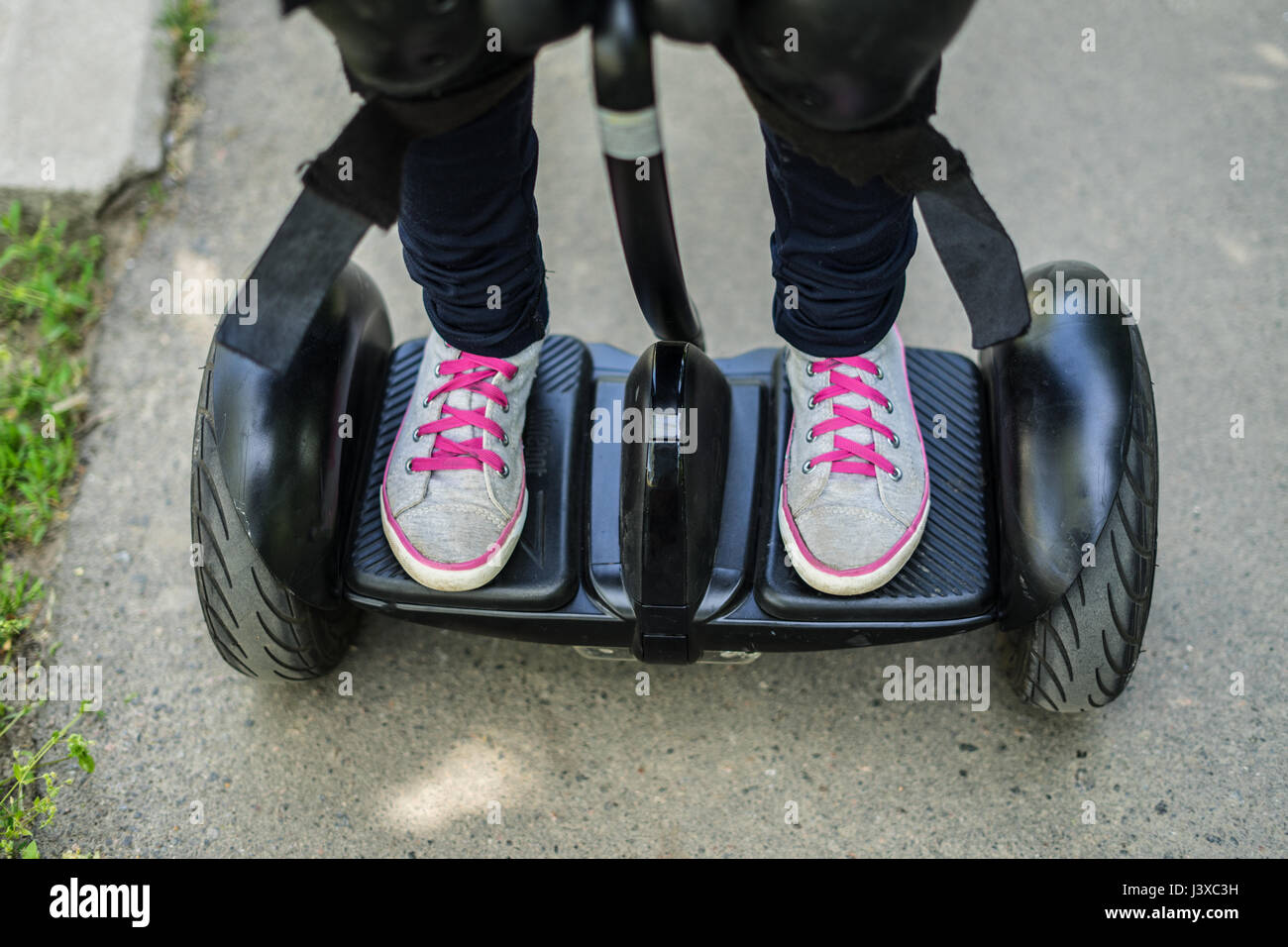 La ragazza gambe indossando scarpe da ginnastica equitazione o gyroscooter  hoverboard Foto stock - Alamy