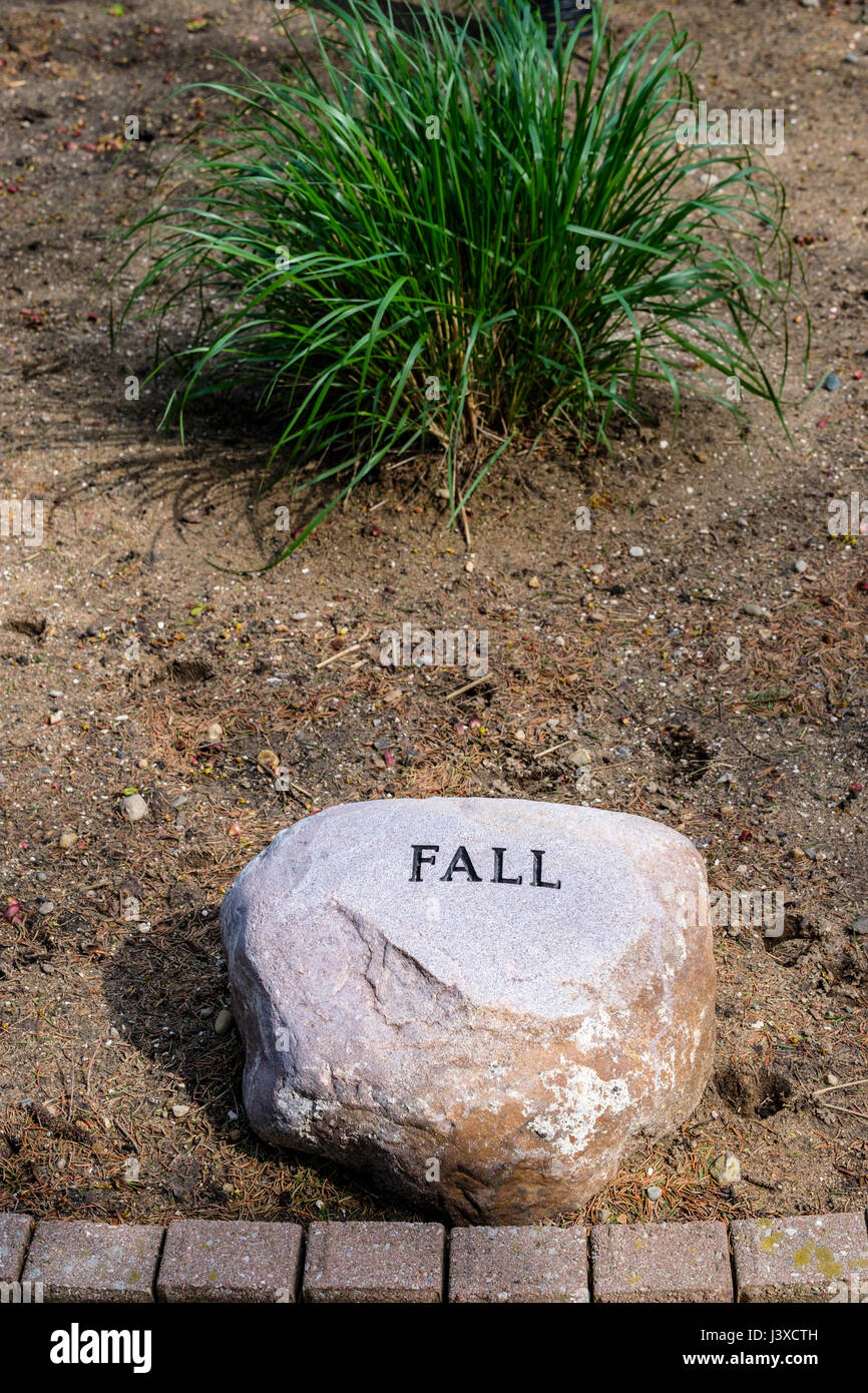 La parola scritta di caduta, incise in rilievo su un giardino decorativo pietra, stagioni dell'anno, giardino decorazione, giardino di pietra, pietra ornamentale, segno di caduta Foto Stock