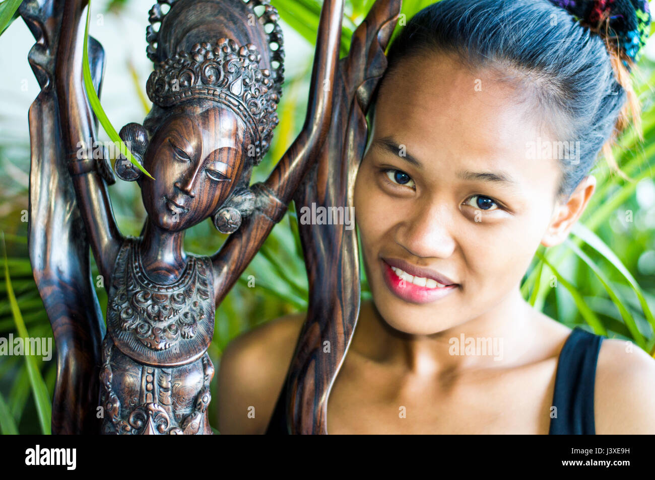 In legno intagliato statua della dea Indionesian, con donna asiatica, in studio di impostazione Foto Stock