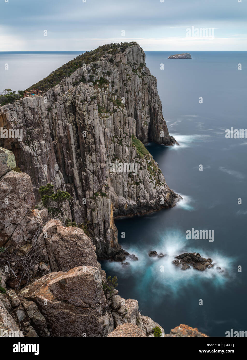 Cape Hauy nella Penisola Tasmana, un promontorio roccioso con morbido movimento oceano e dinamico, spostando le nuvole (lunga esposizione) Foto Stock