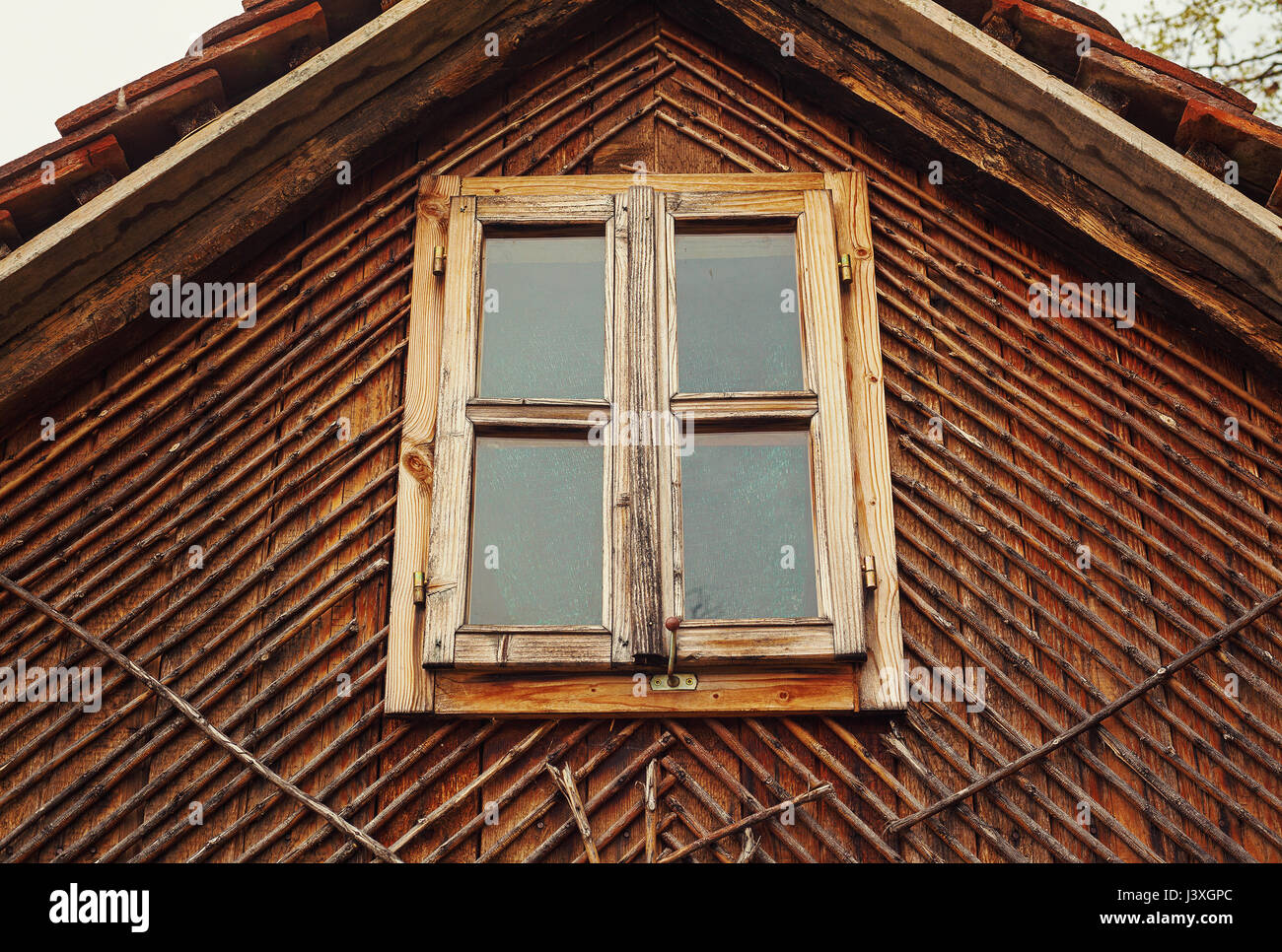 Camera loft di una vecchia casa in legno, outdoor view sulla finestra e struttura del tetto. Foto Stock