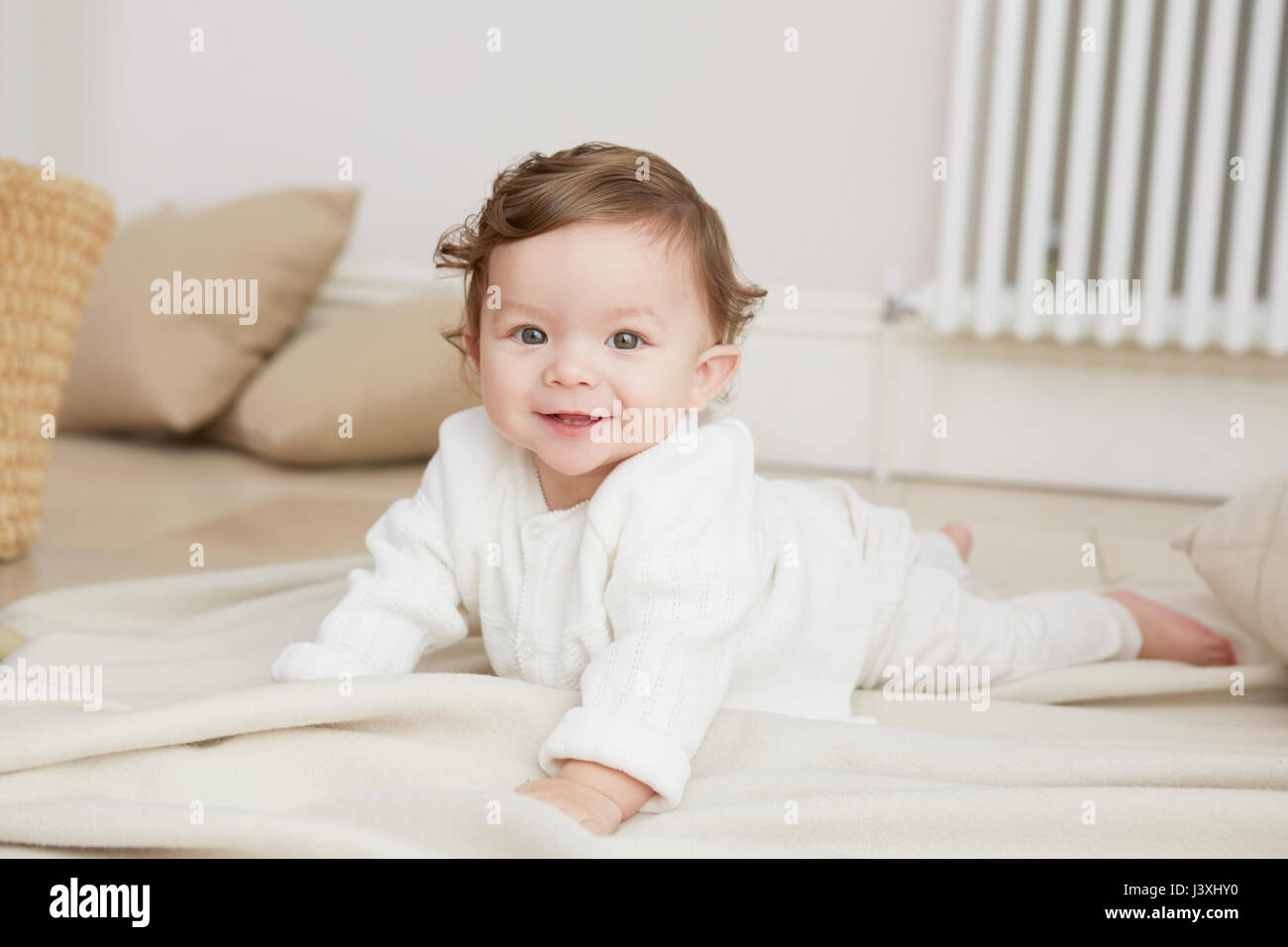 Ritratto di bambina giacente sul suo fronte, sorridente Foto Stock