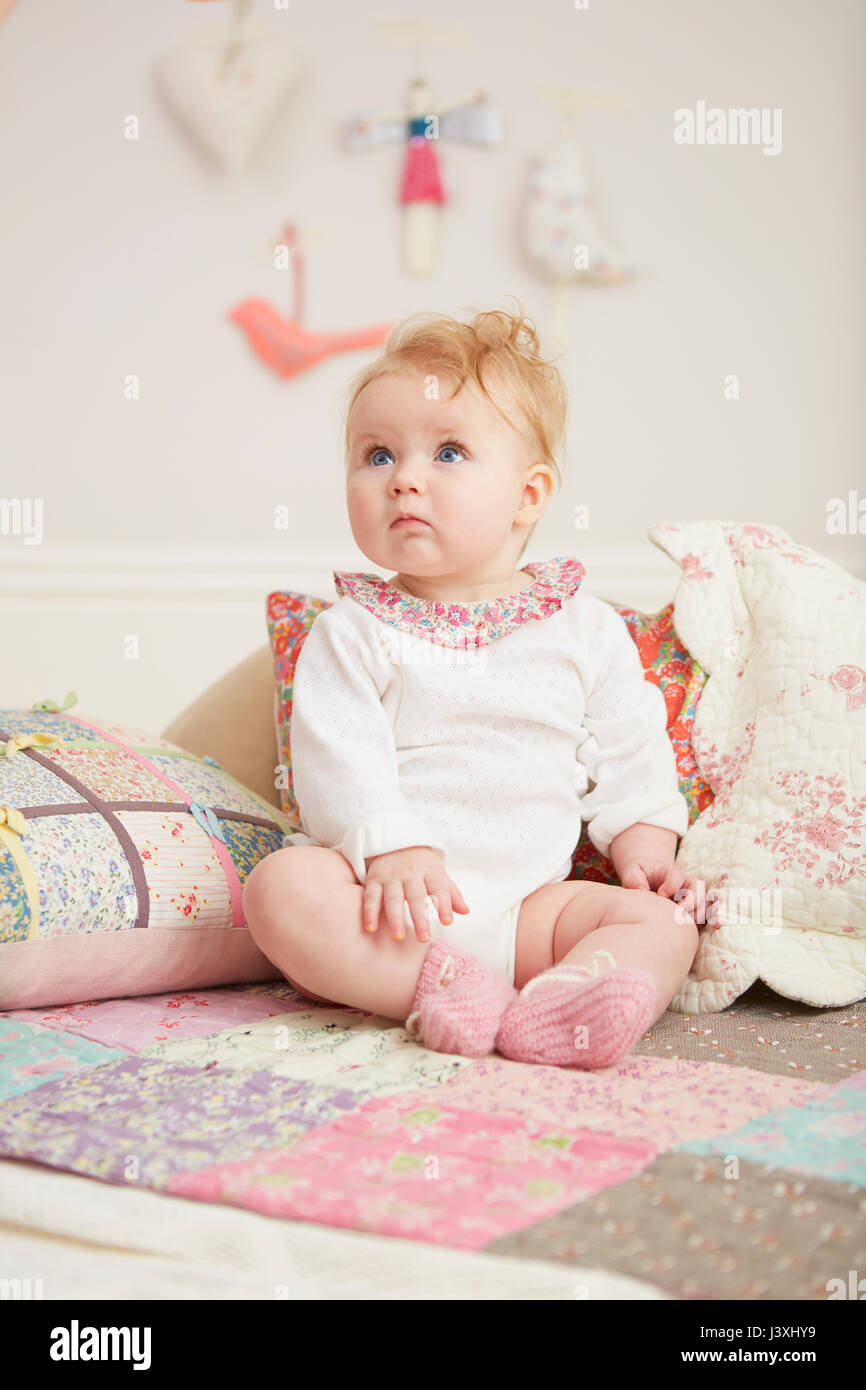 Ritratto di baby sitting fino a fianco di cuscini Foto Stock