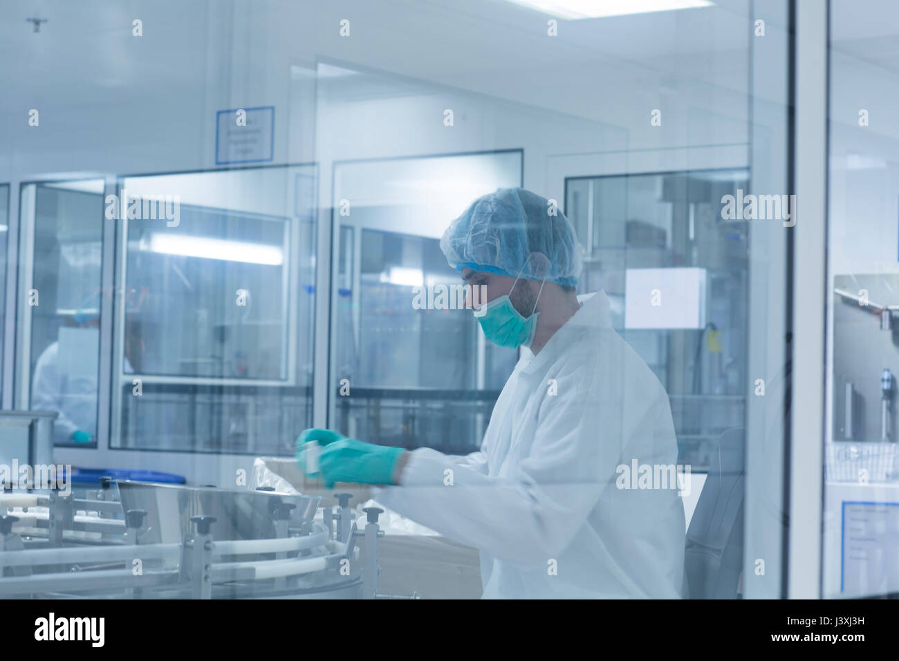 Lavoratore il confezionamento di prodotti in stabilimento farmaceutico Foto Stock