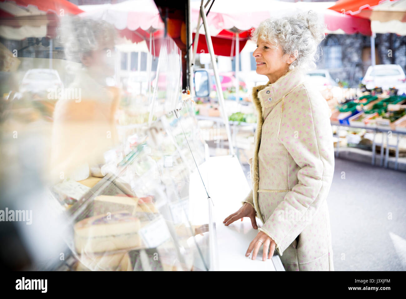 Femmina matura shopper acquistare il formaggio a livello locale per il mercato francese Foto Stock