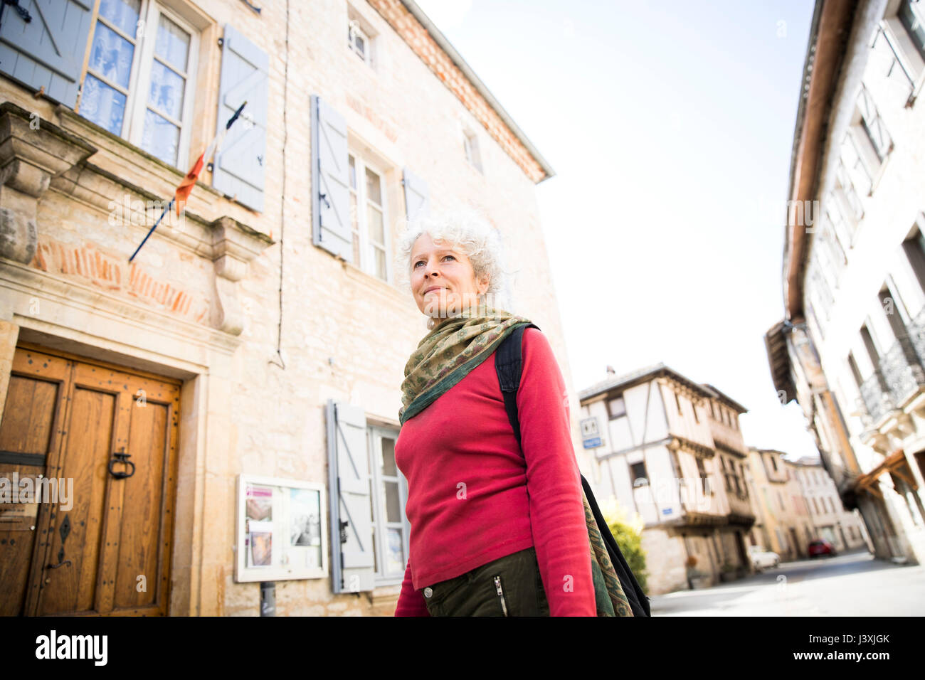 Donna in strada guardando lontano. Bruniquel, Francia Foto Stock