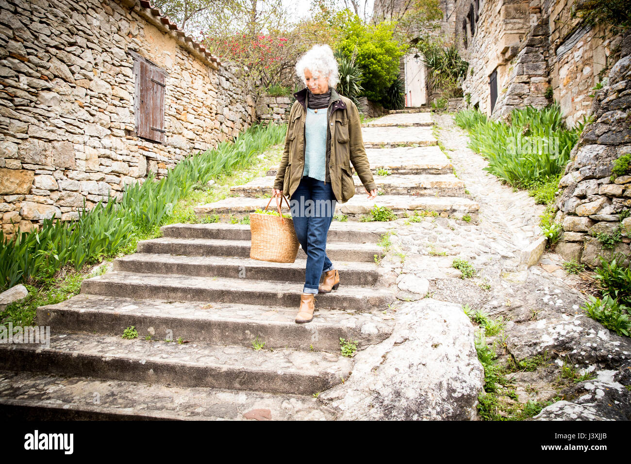 Donna che cammina verso il basso passi, Bruniquel, Francia Foto Stock