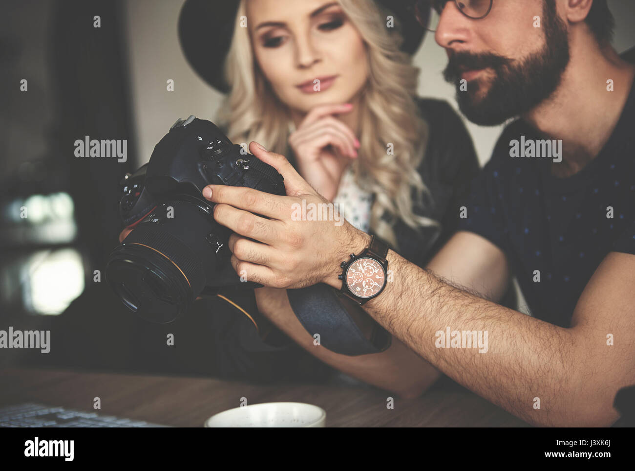 Fotografi esaminando il lavoro sulla fotocamera in studio fotografico Foto Stock