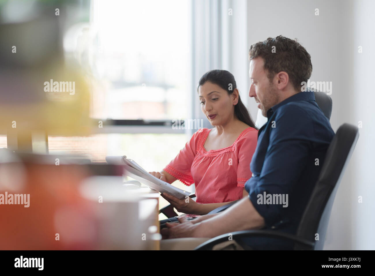 I colleghi in discussione alla scrivania in ufficio Foto Stock