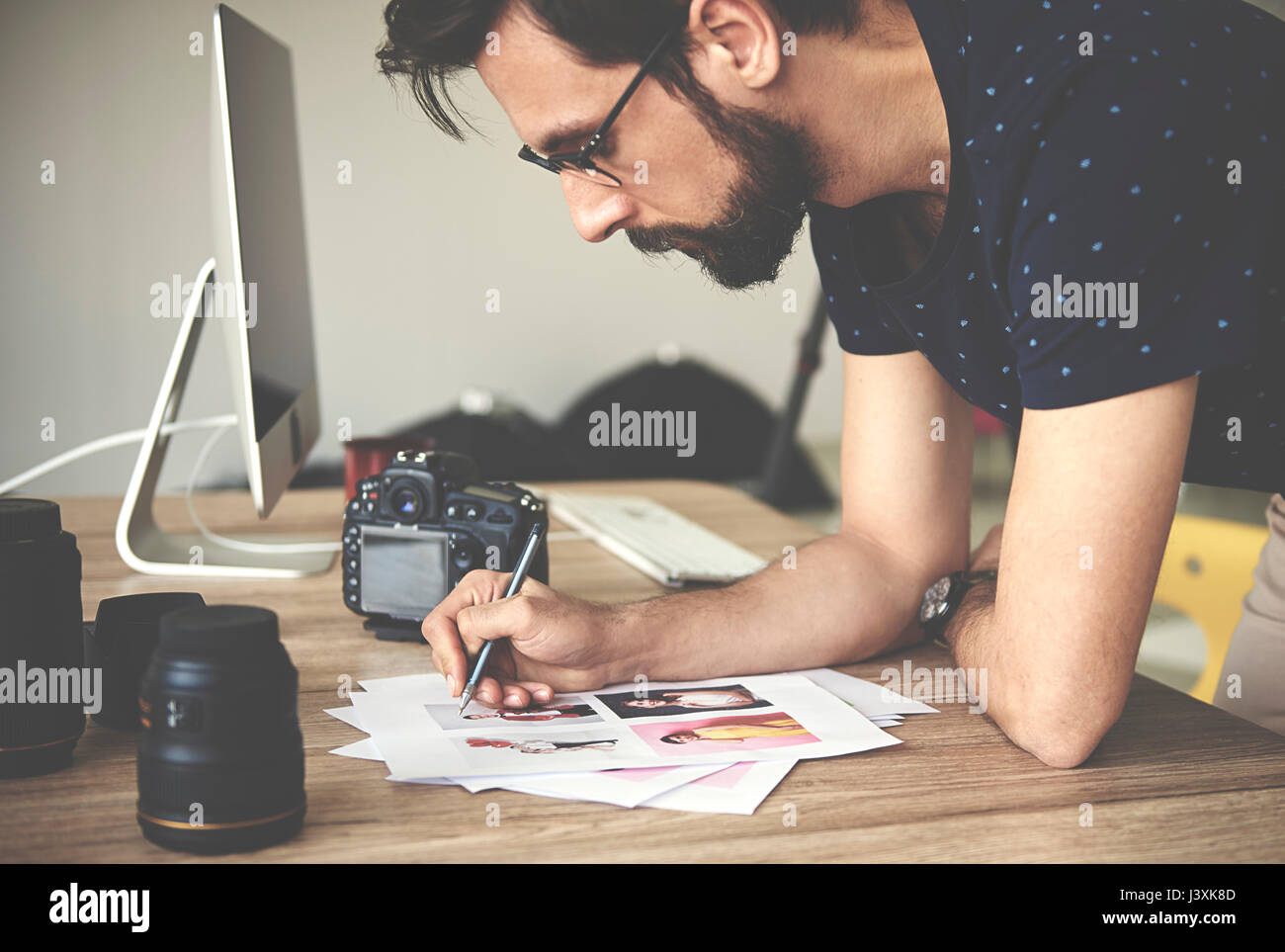 Fotografo rendendo note sulle fotografie in studio fotografico Foto Stock